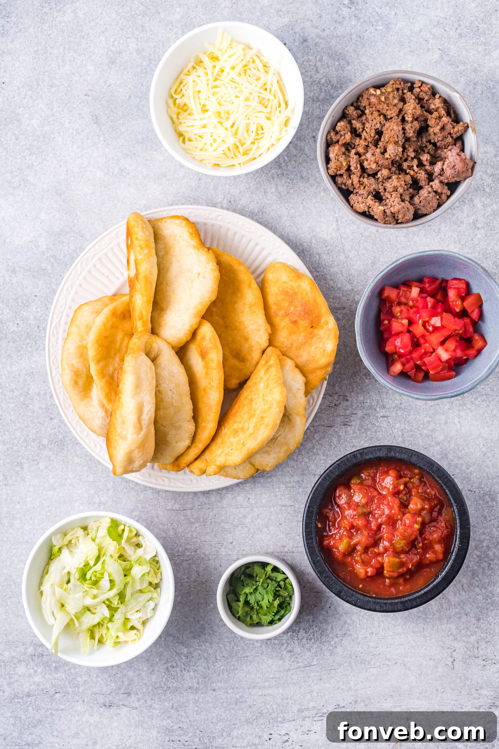 A close-up of various Taco Bell Chalupa ingredients organized in individual small bowls, highlighting their freshness and readiness for assembly.