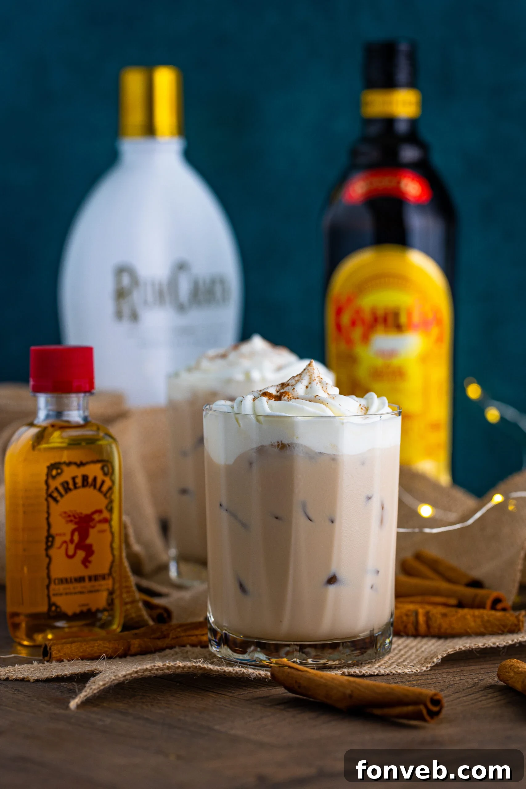 Front view of Cinnamon Roll Cocktail surrounded by cinnamon sticks.