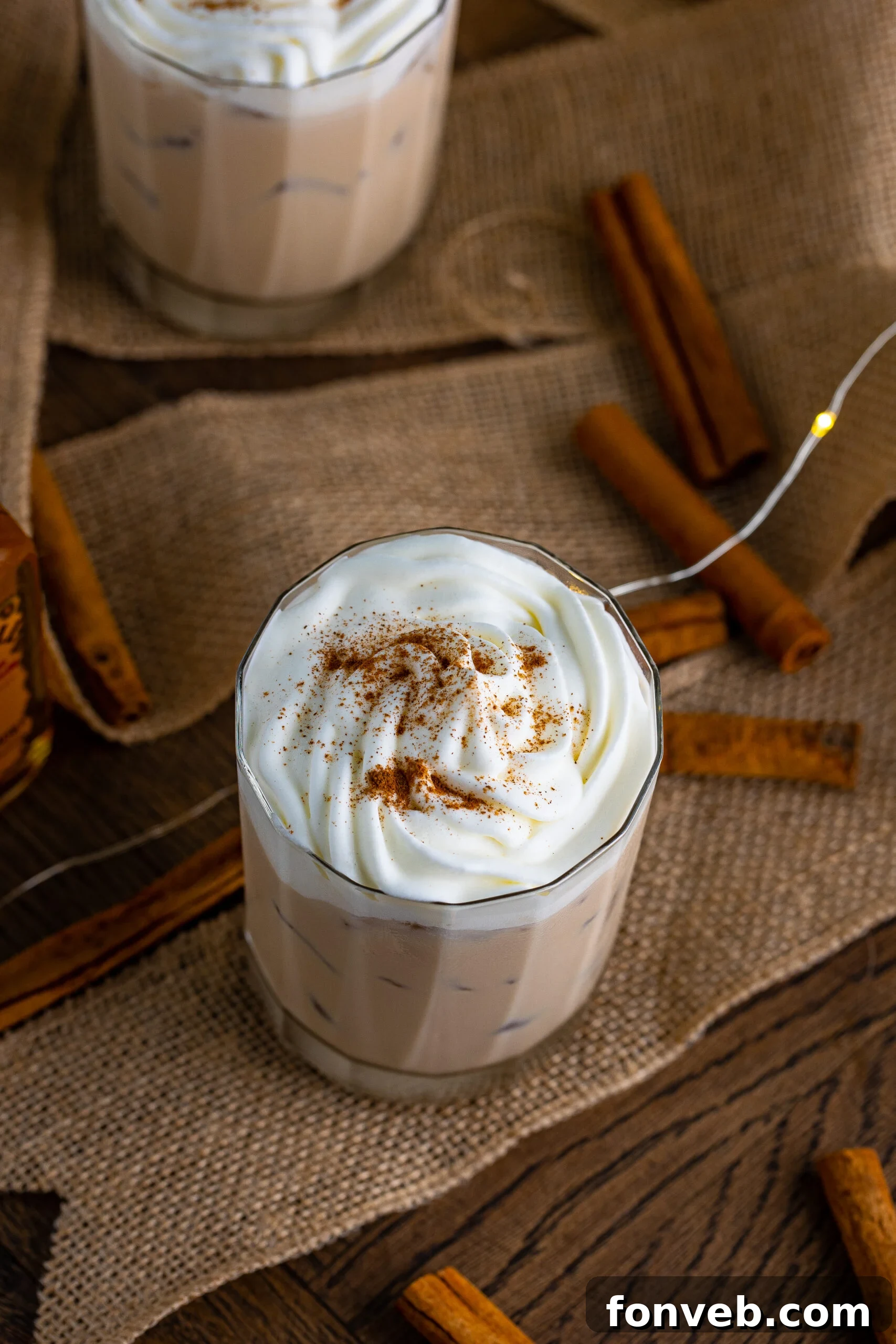 Overhead view of Cinnamon Roll Cocktail Surrounded by cinnamon sticks.