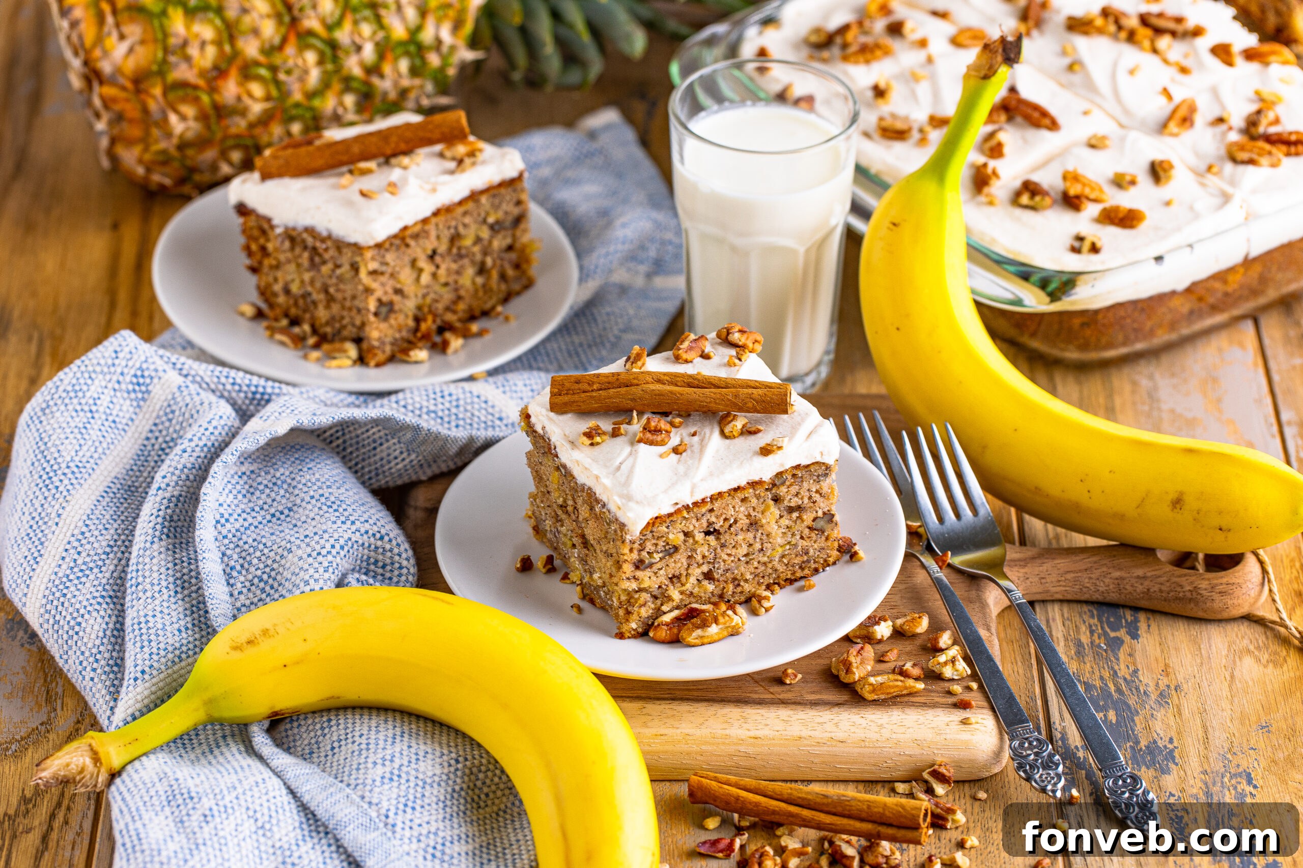 A wide shot of a whole Hummingbird Cake, beautifully frosted with cream cheese icing and sprinkled with chopped nuts.