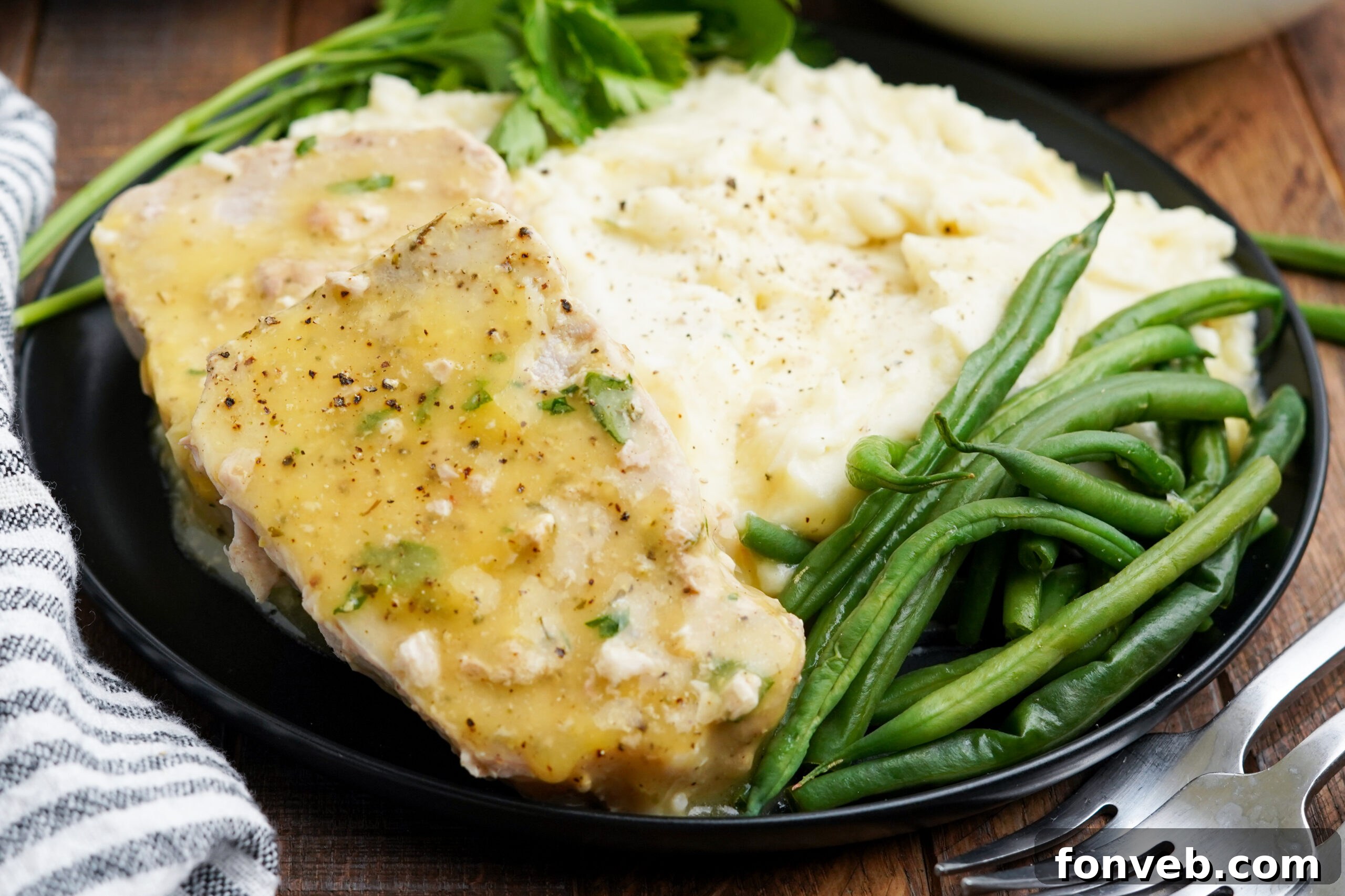 Front view of Crock Pot Ranch Pork Chops served with mashed potatoes and green beans.