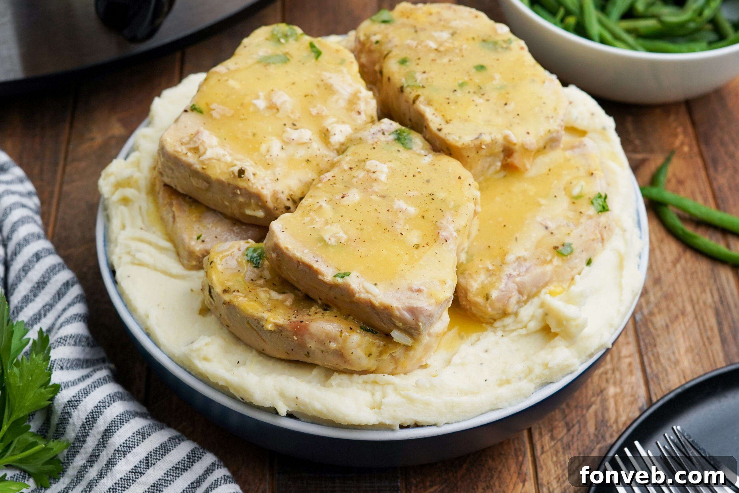 Front view of Crock Pot Ranch Pork Chops served over mashed potatoes.
