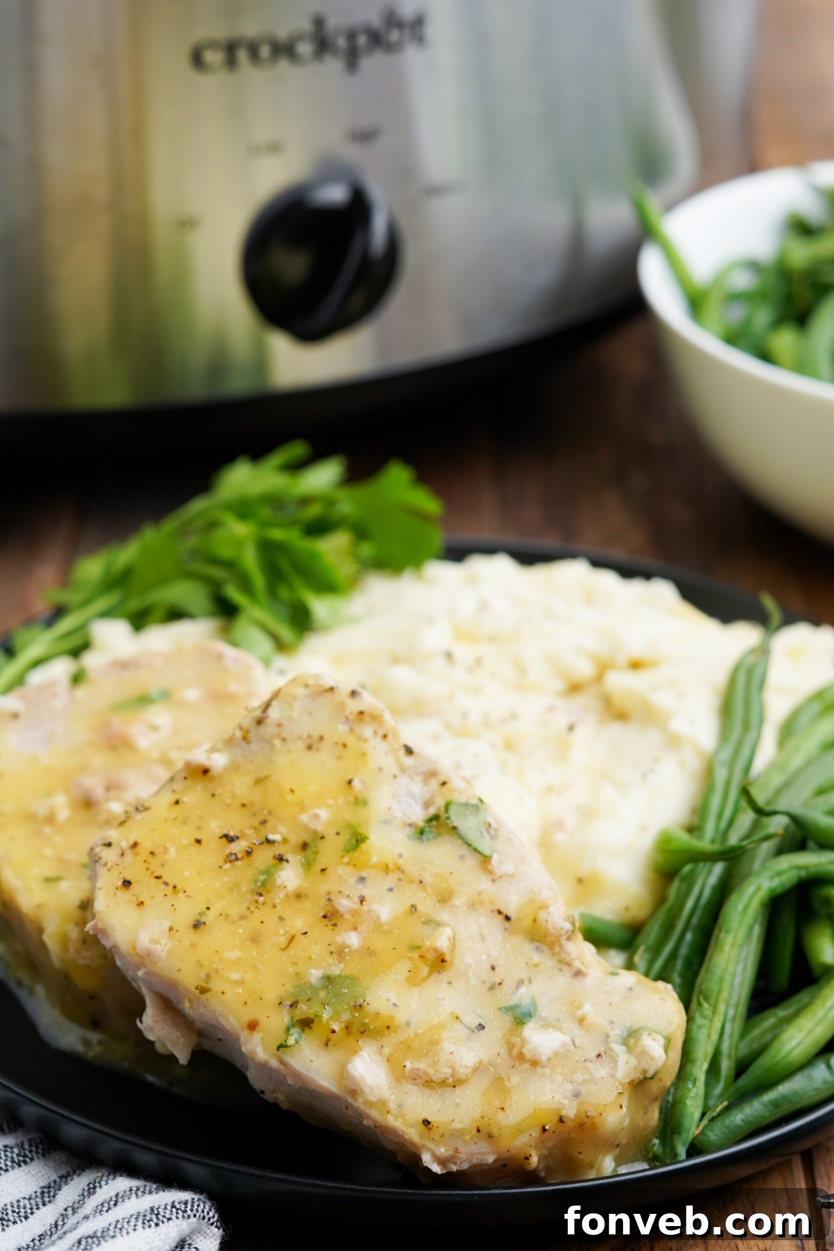Close up view of Crock Pot Ranch Pork Chops served with mashed potatoes and green beans.