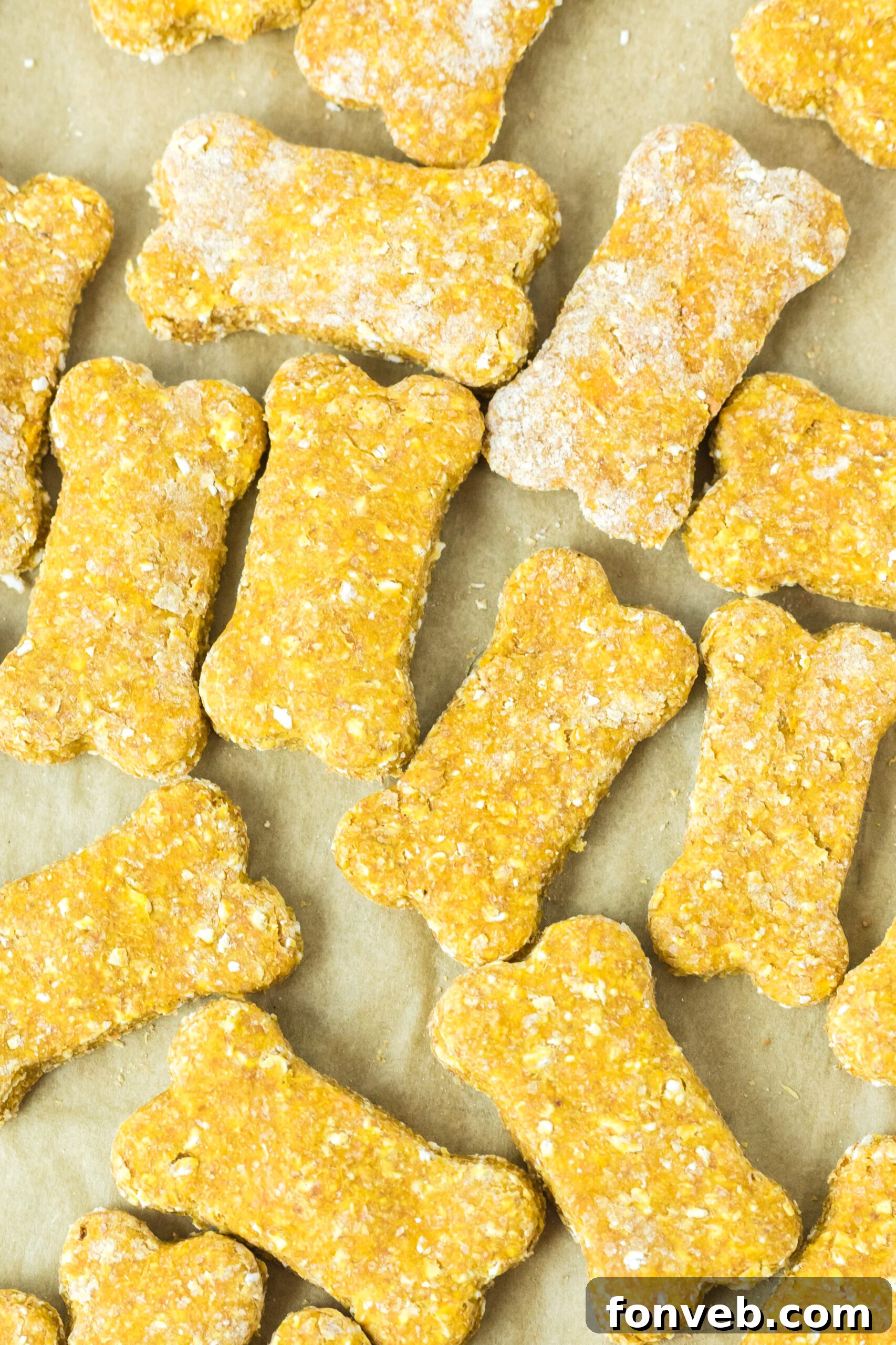 An inviting overhead shot of baked Sweet Potato and Pumpkin Dog Treats cooling on a piece of parchment paper, showcasing their perfect golden-brown finish.