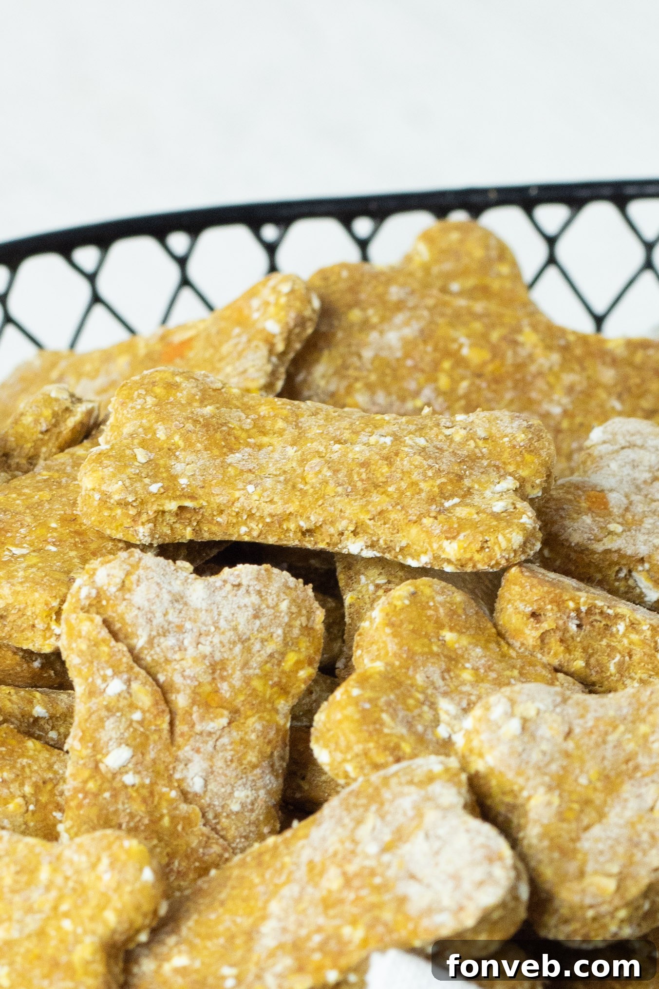 An artistic close-up capturing the rustic texture of the Sweet Potato and Pumpkin Dog Treats, perhaps with a hint of their ingredients visible, presented in a vintage-style basket.