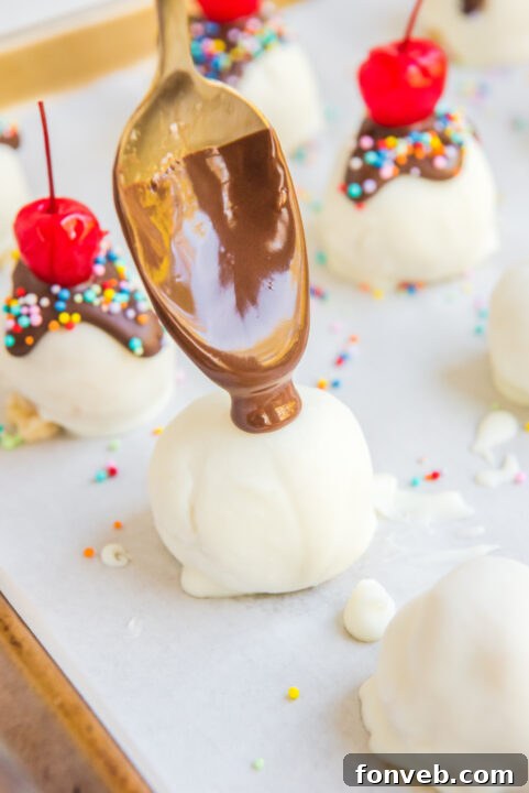 A truffle ball being dipped into the melted white chocolate coating, ensuring full and even coverage.