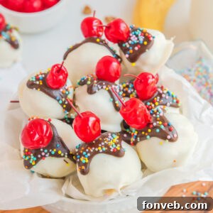A delectable Banana Split Truffle, coated in white chocolate and drizzled with dark chocolate, adorned with a cherry and sprinkles.