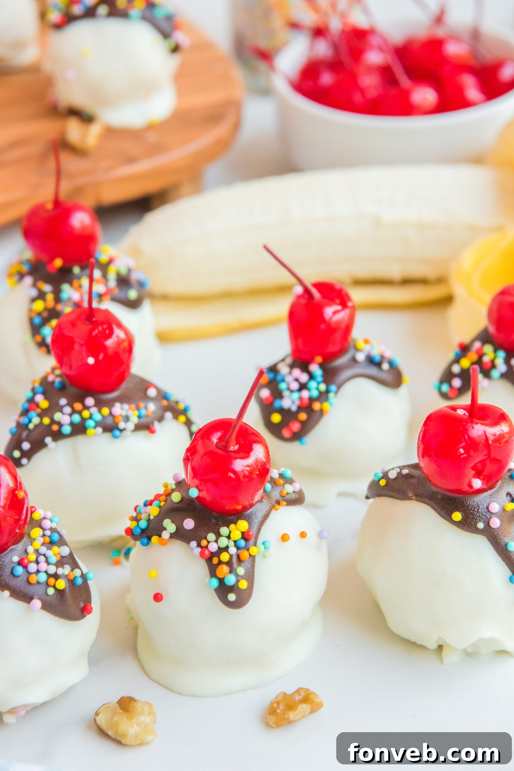 A vibrant display of Banana Split Truffles, generously coated and topped, with a scattering of chopped walnuts providing a rustic touch around them.