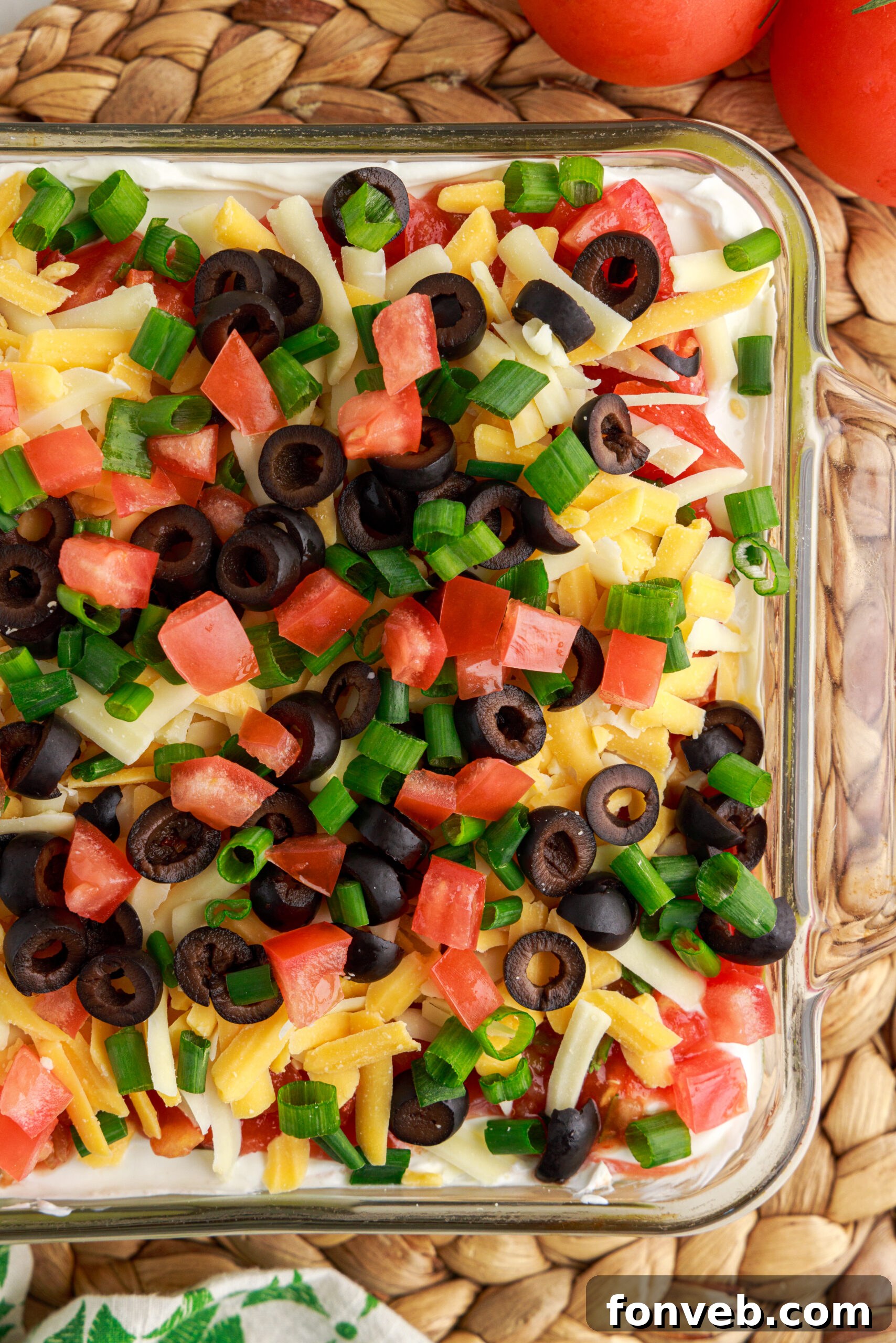 An inviting overhead view of the complete 7-Layer Dip, presented in a clear baking dish, emphasizing its colorful and appealing appearance.