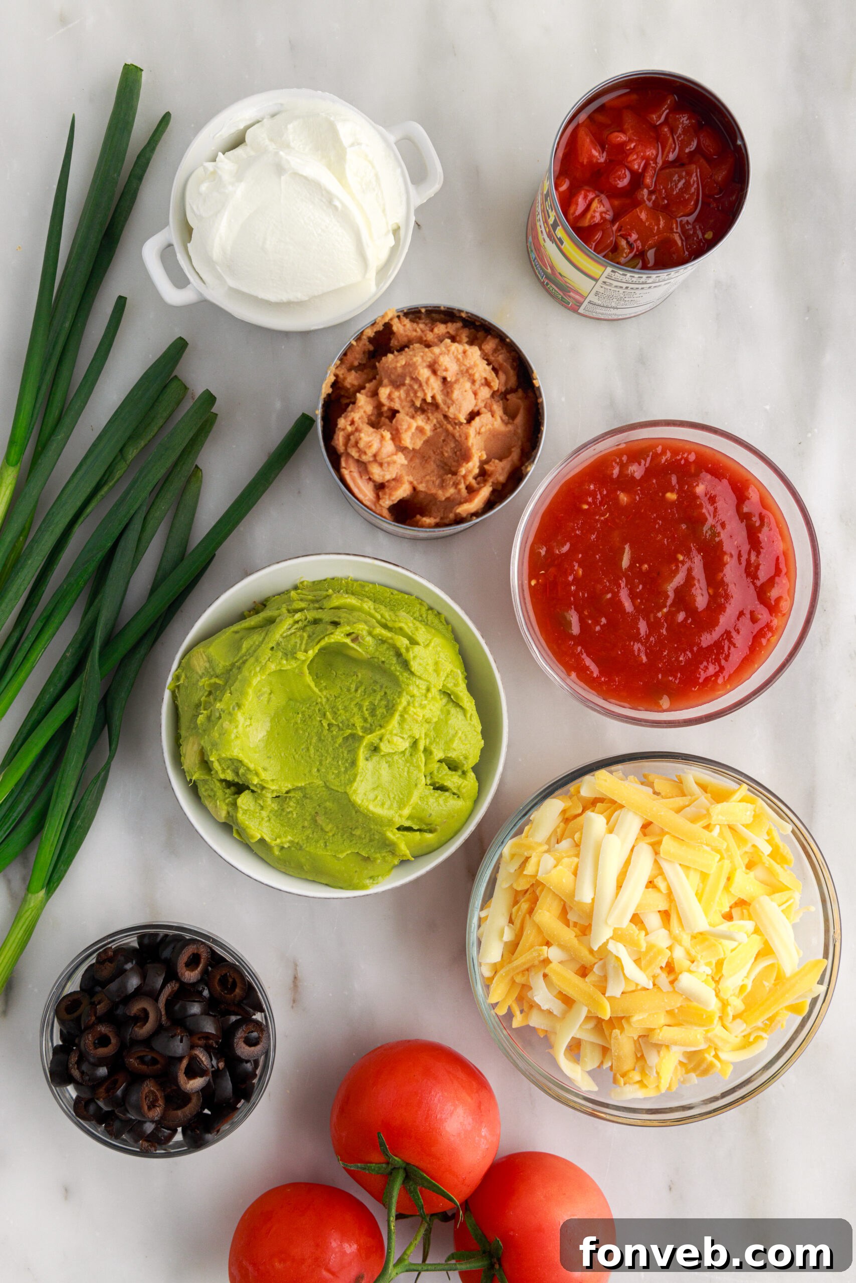 An overhead shot showcasing all the fresh and packaged ingredients laid out, ready to be assembled into the delicious 7-Layer Dip.