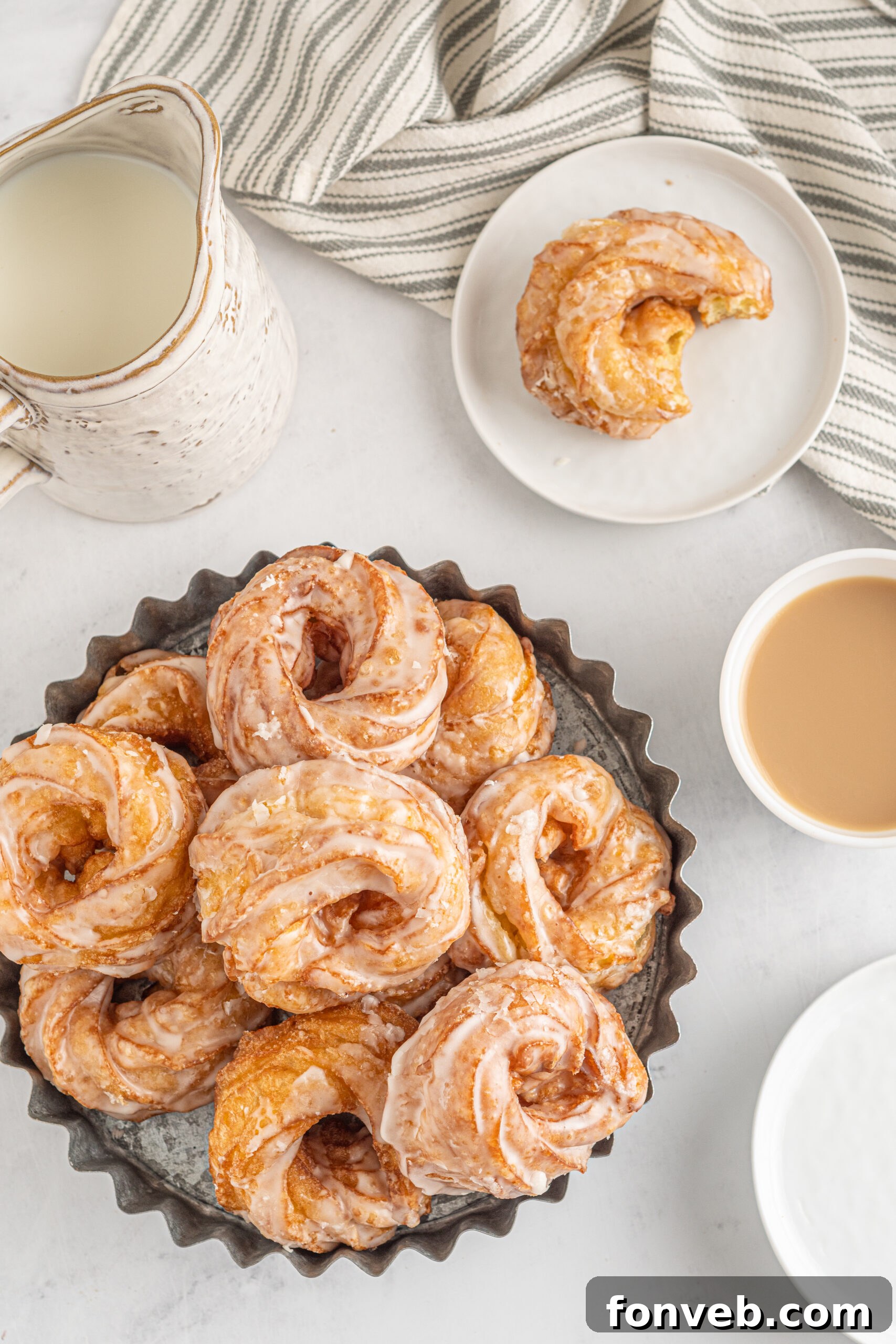 Overhead view of French Crullers stacked on a silver serving tray.