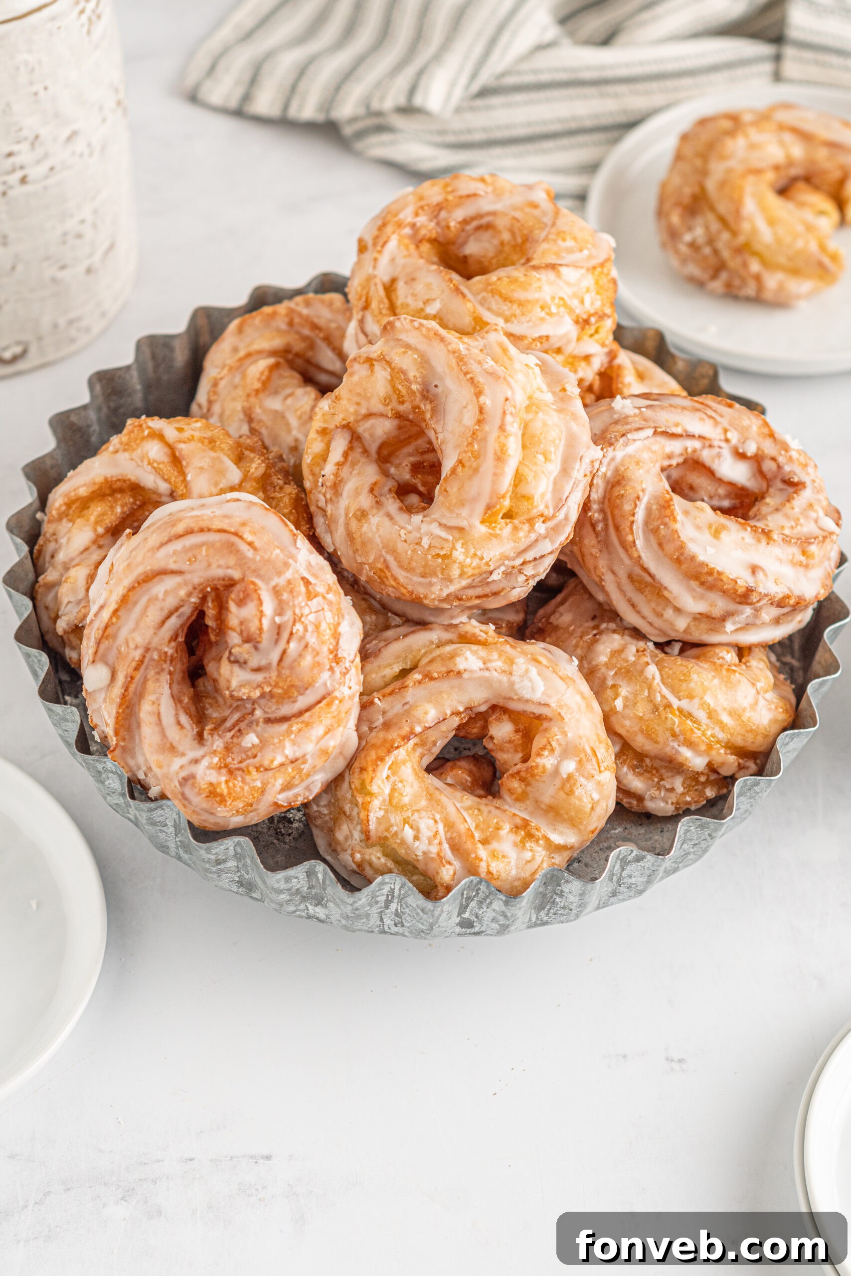Overhead view of French Crullers stacked on a silver serving tray.