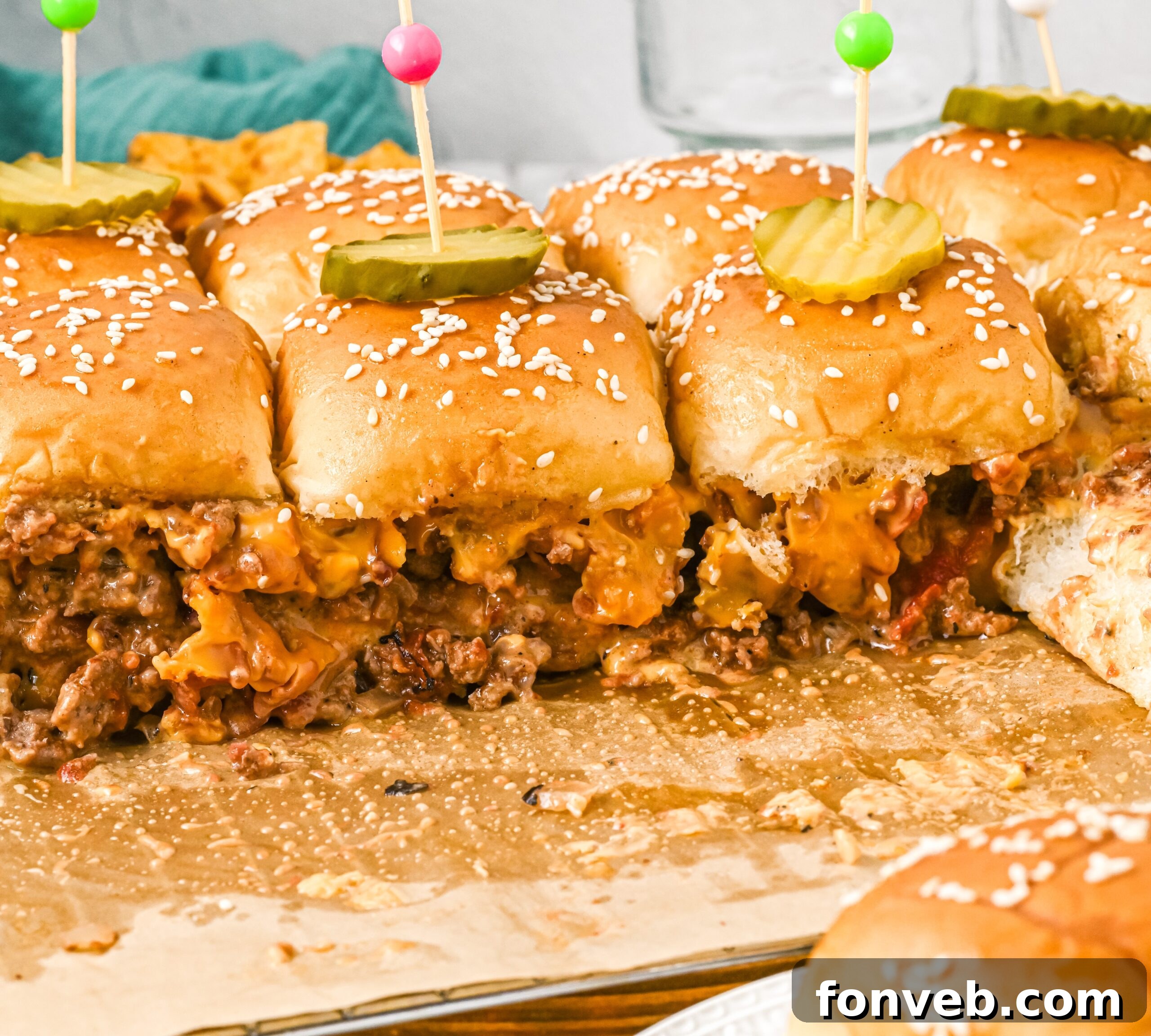 A delicious array of bacon cheeseburger sliders, featuring melted cheese and crispy bacon, viewed from the side, showcasing their tempting layers.