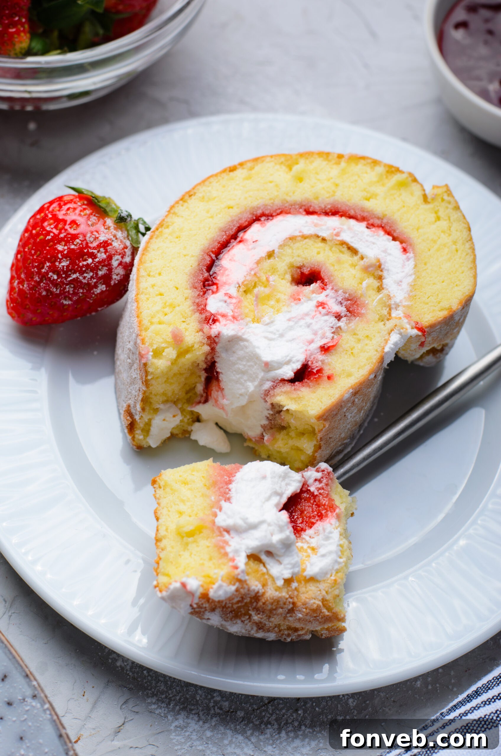Overhead view of a slice of Strawberries & Cream Cake Roll with a bite removed