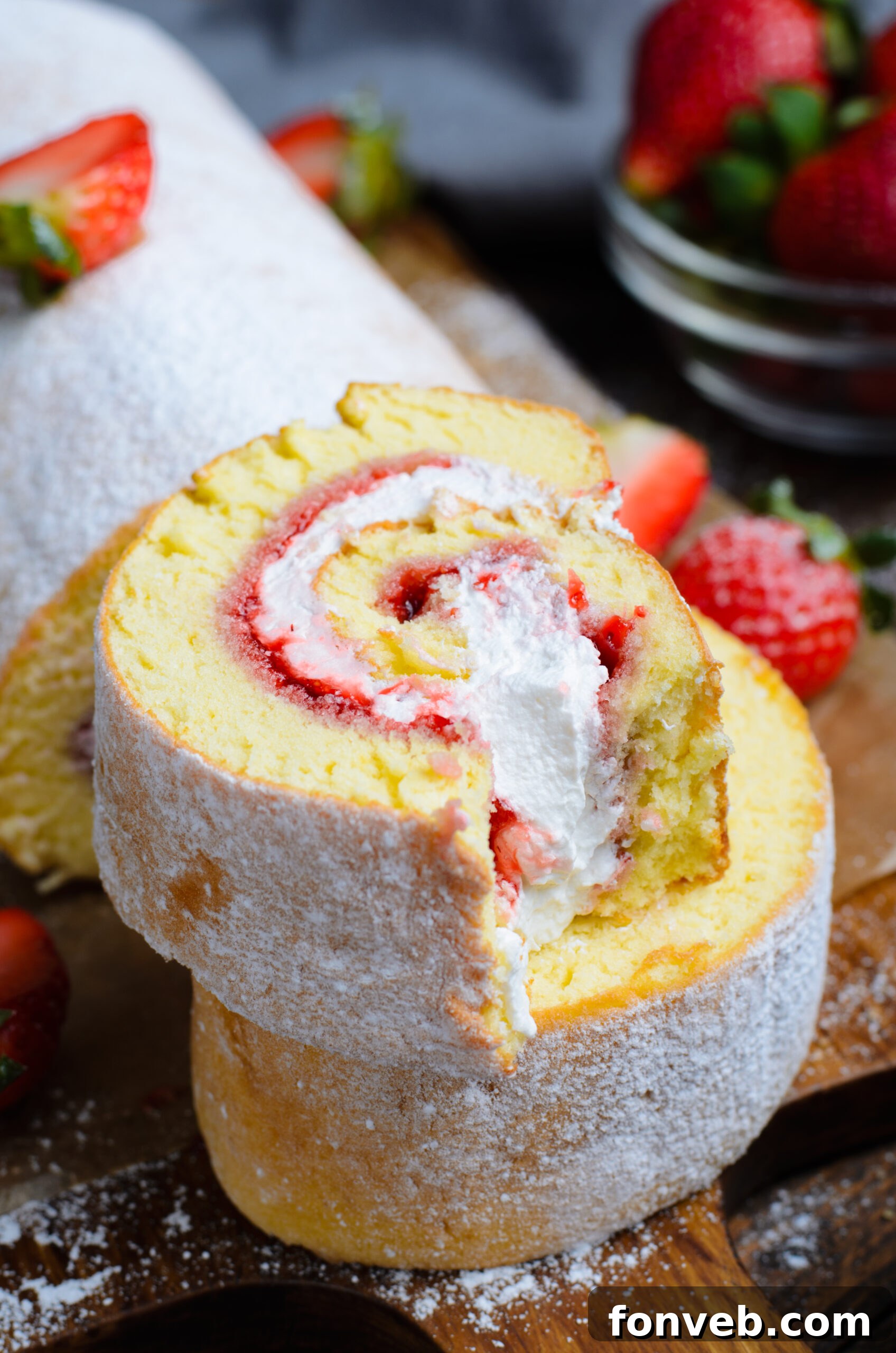 Front view of two slices of Strawberries & Cream Cake Roll stacked with a bite removed from the top slice.