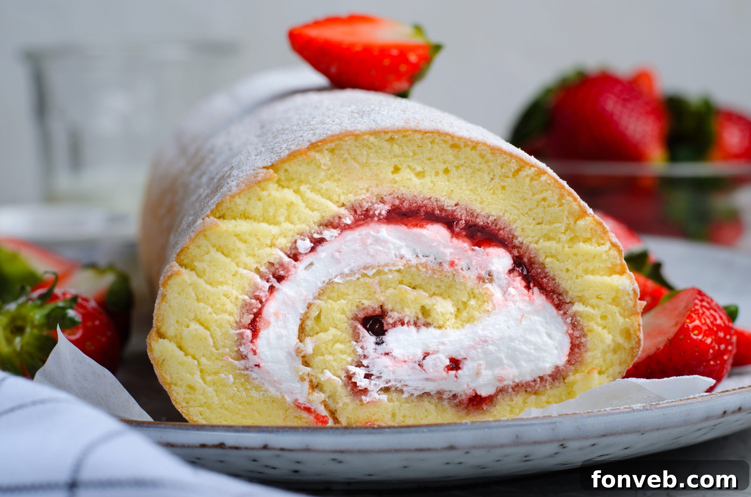 Front view of Strawberries & Cream Cake Roll on a white serving dish.