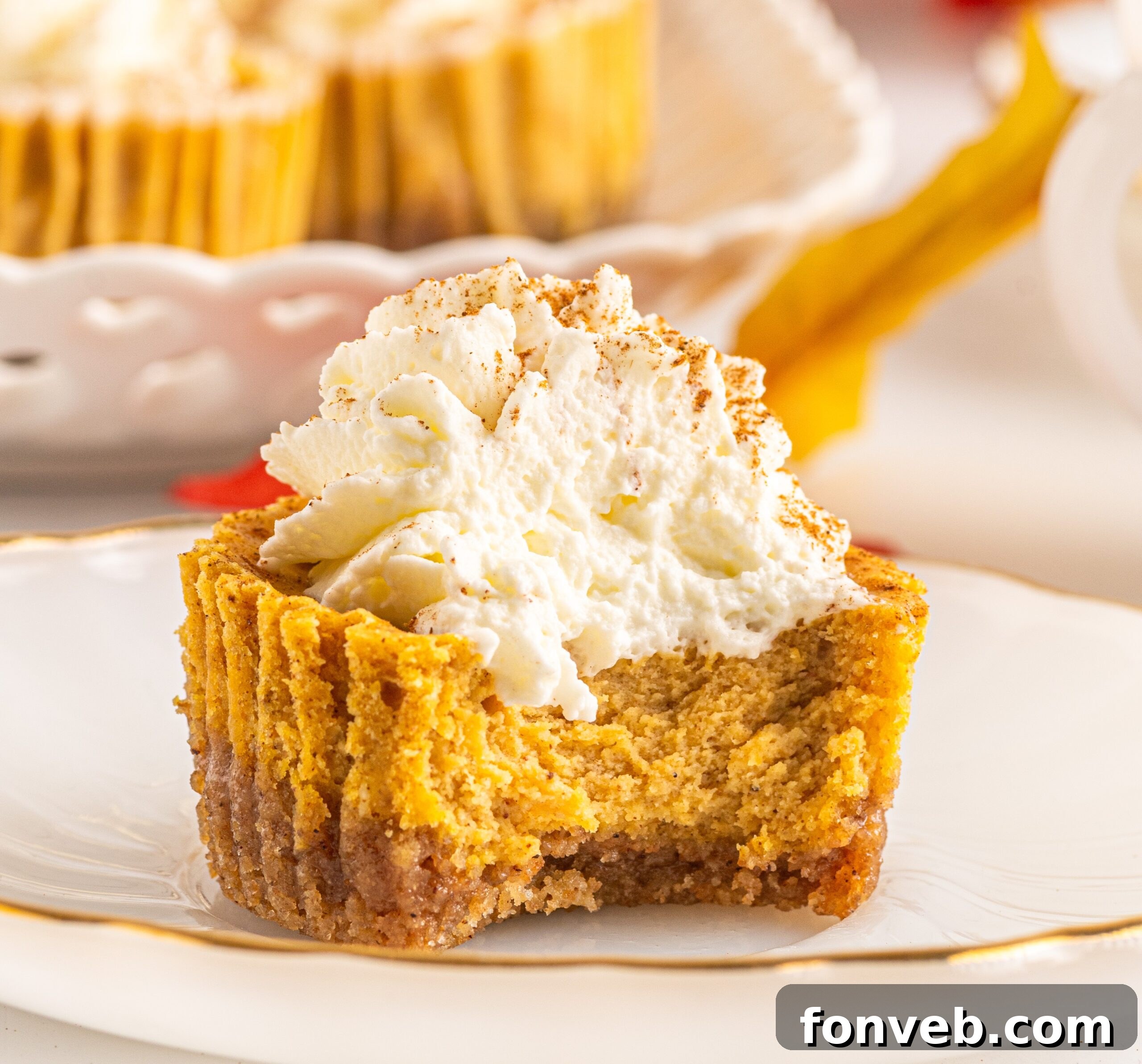 Spiced Fall Cheesecake Bites 2 Beautifully arranged mini pumpkin cheesecakes on a serving platter, showcasing their velvety pumpkin filling and golden graham cracker crust.