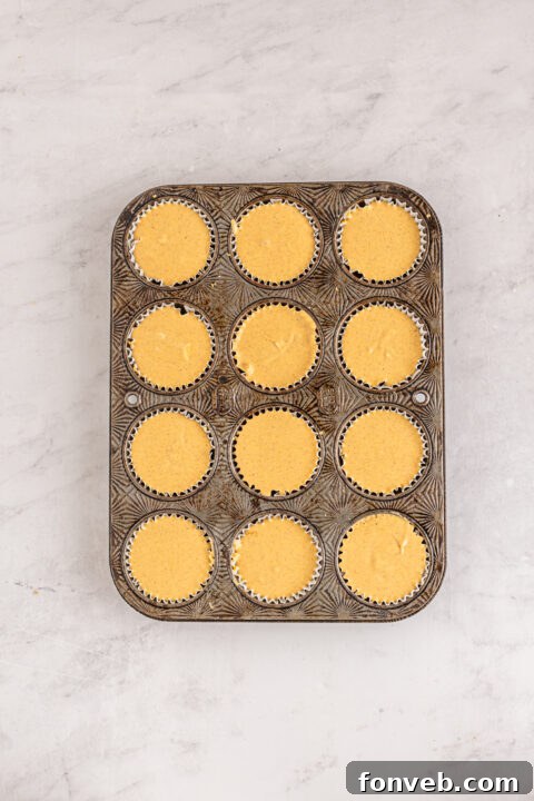 Spiced Fall Cheesecake Bites 15 A batch of mini pumpkin cheesecakes cooling on a rack.