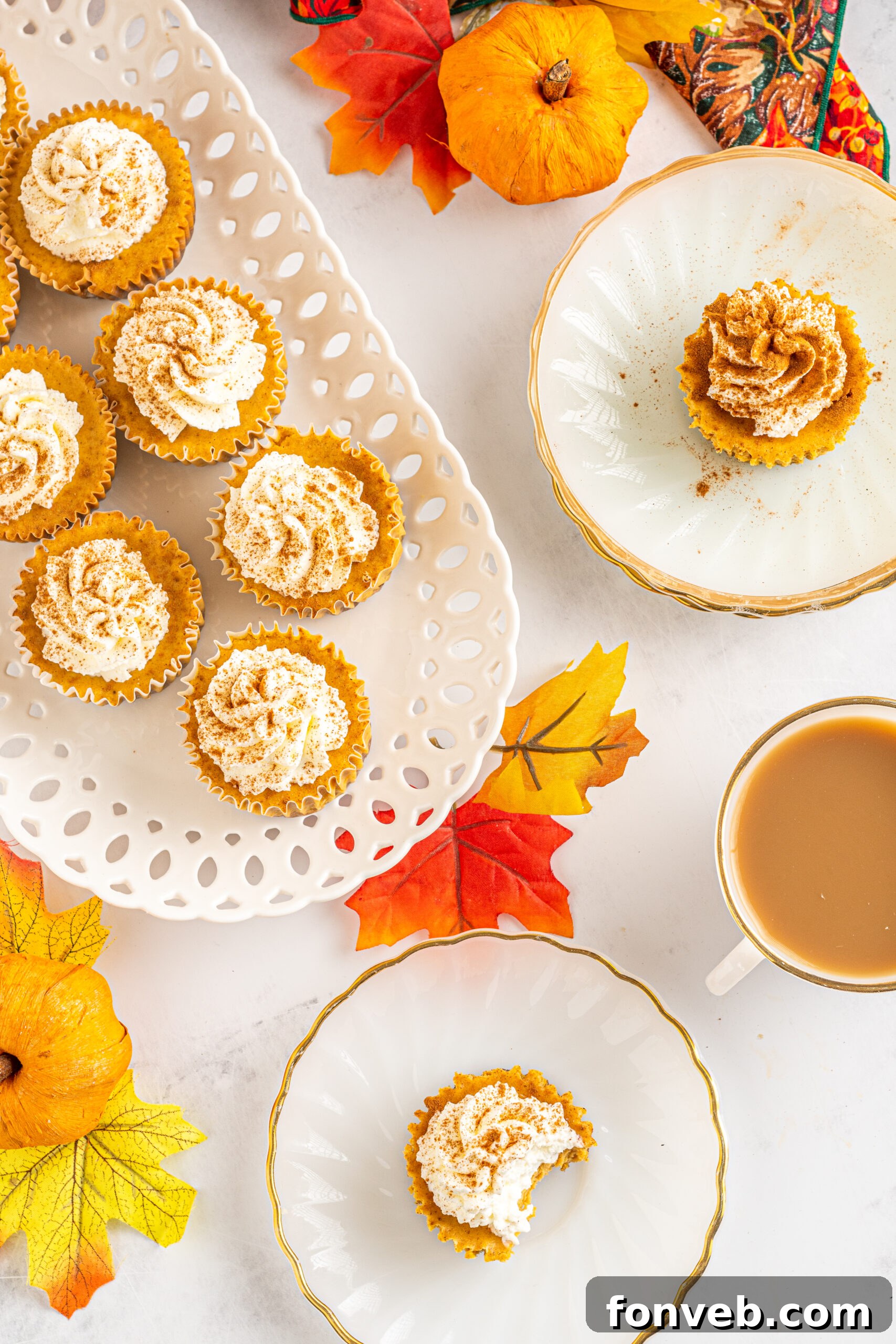 Spiced Fall Cheesecake Bites 16 Overhead view of several Mini Pumpkin Cheesecakes presented on individual white dishes.
