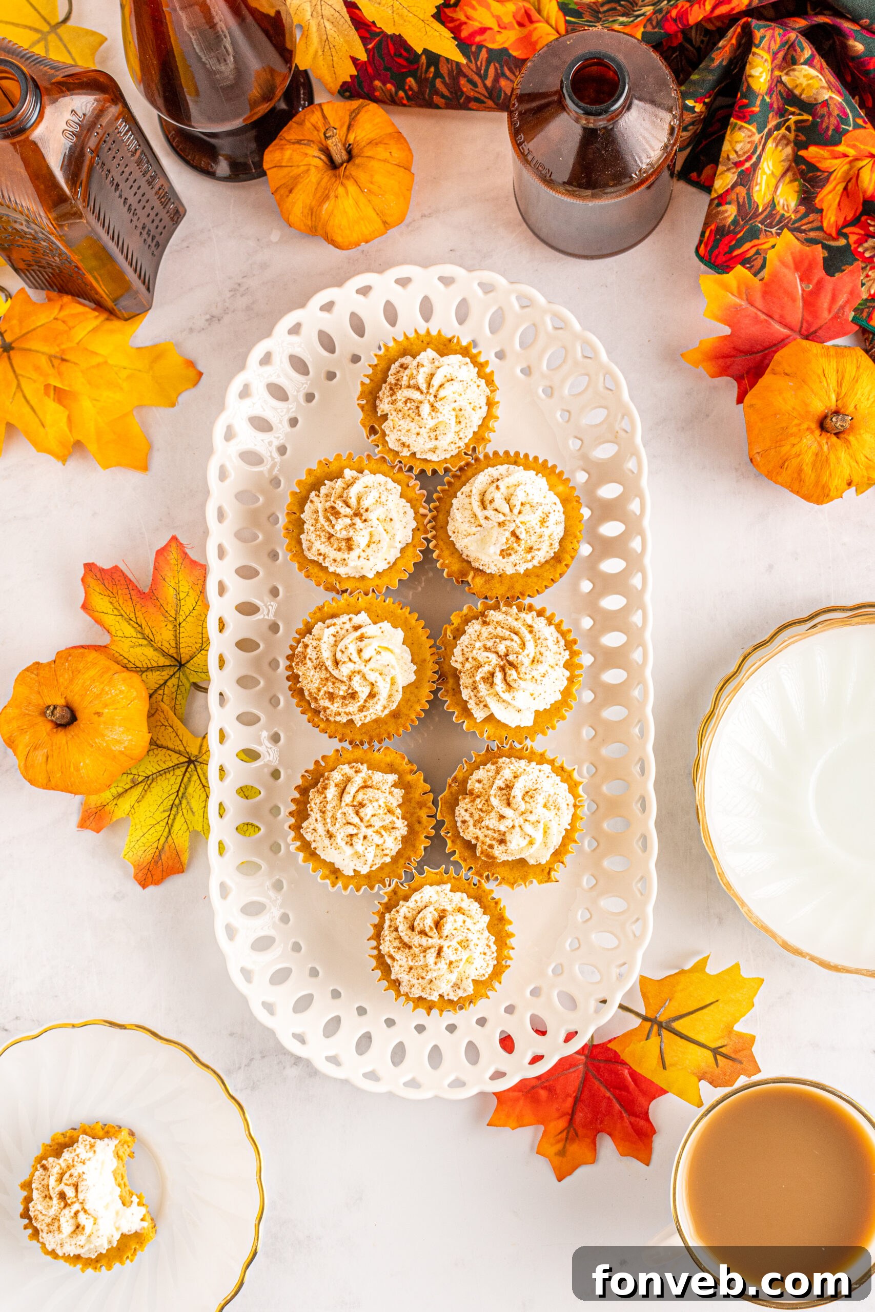 Spiced Fall Cheesecake Bites 3 Overhead view of Mini Pumpkin Cheesecakes on a white serving dish, perfectly golden and garnished for autumn.