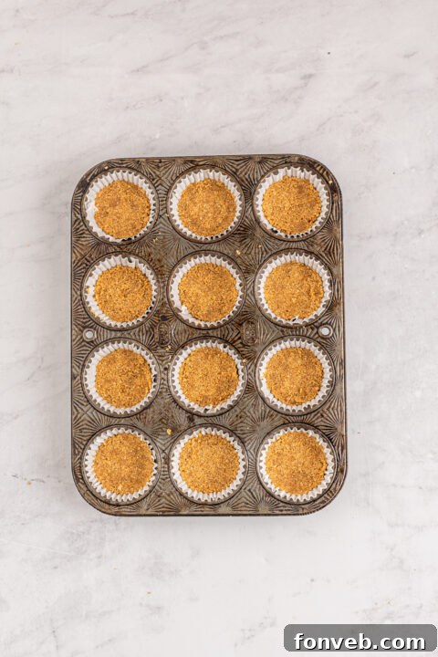 Spiced Fall Cheesecake Bites 10 A collection of mini pumpkin cheesecakes in cupcake liners, ready for decoration.