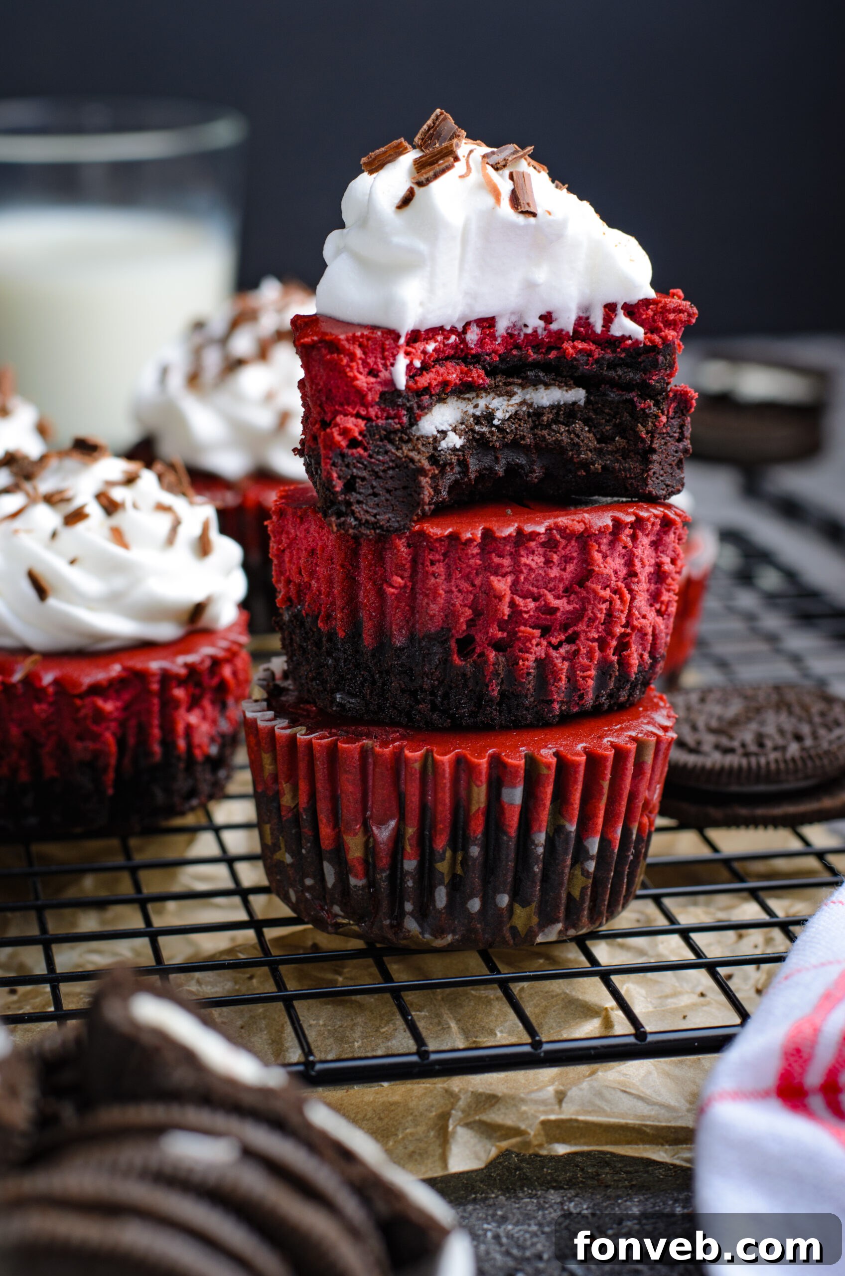Ruby Red Oreo Cheesecake Gems 9 Front view of three Mini Red Velvet Oreo Cheesecakes stacked with a bite removed from the top cheesecake.
