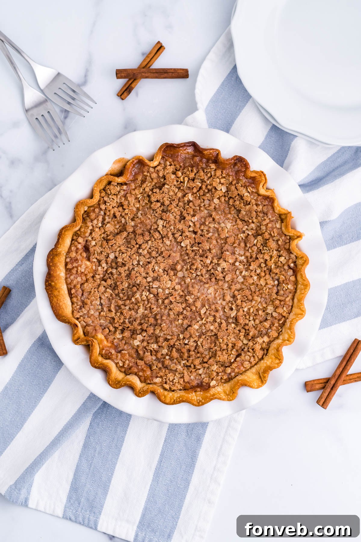 Caramel Apple Crumble Cheesecake Pie 4 Overhead view of Apple Crumb Cheesecake Pie in a white pie dish.