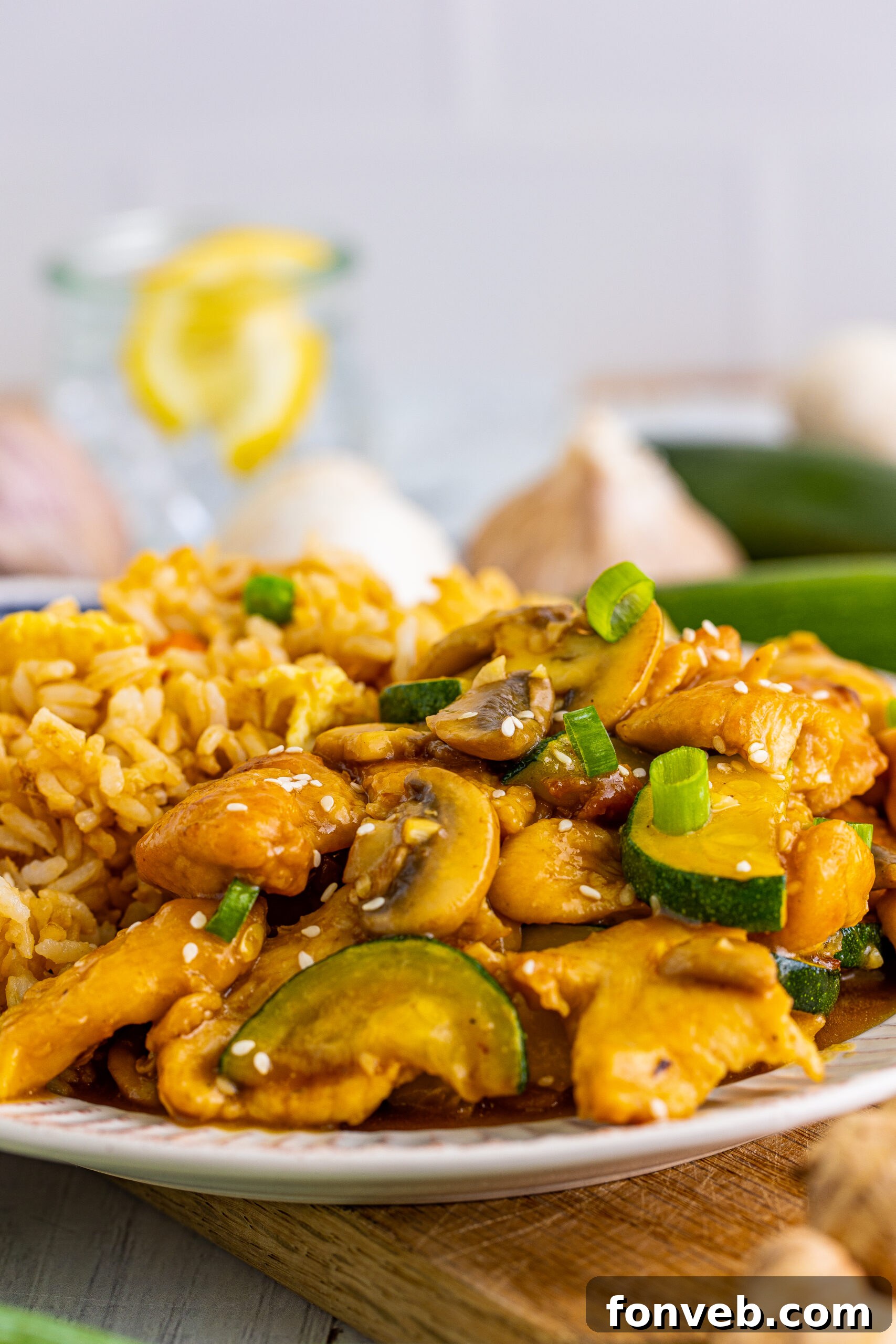 Close up view of Panda Express Mushroom Chicken on a white dish served with fried rice.