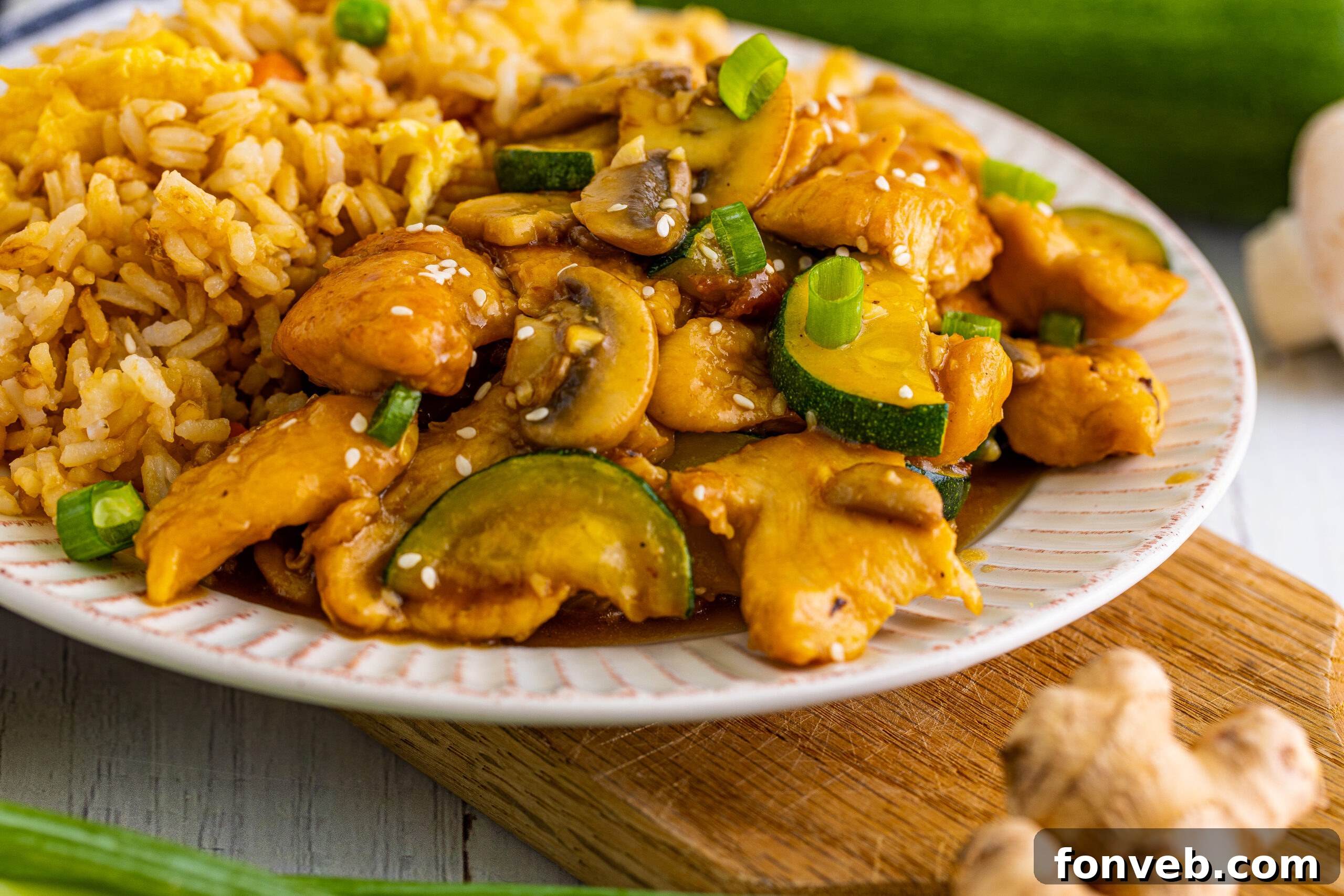 Front view of Panda Express Mushroom Chicken on a white dish served with fried rice.