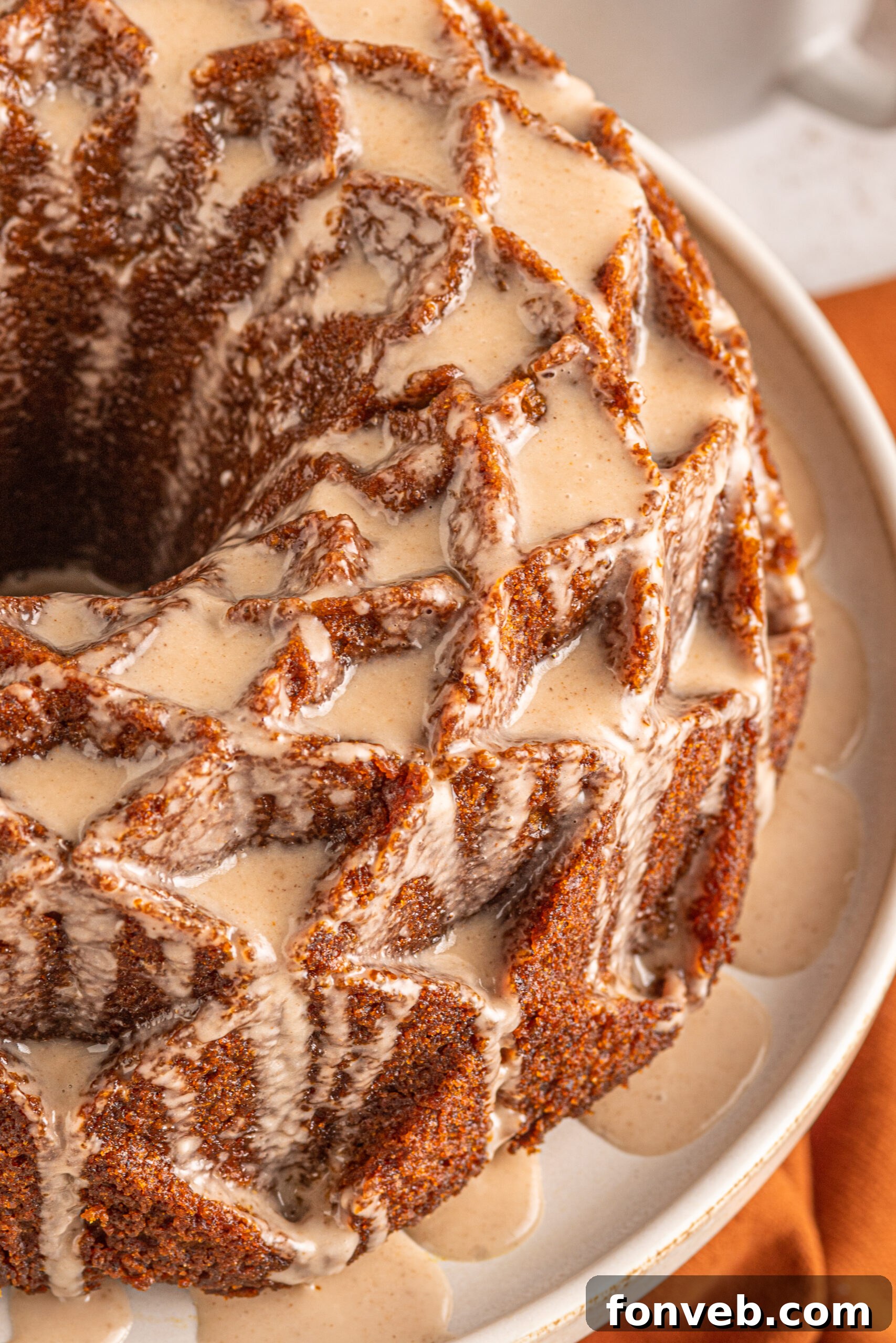 Harvest Pumpkin Bundt with Sweet Cinnamon Finish 2 Close up view of a golden brown Pumpkin Bundt Cake with a shimmering Cinnamon Sugar Glaze on an elegant cake stand.