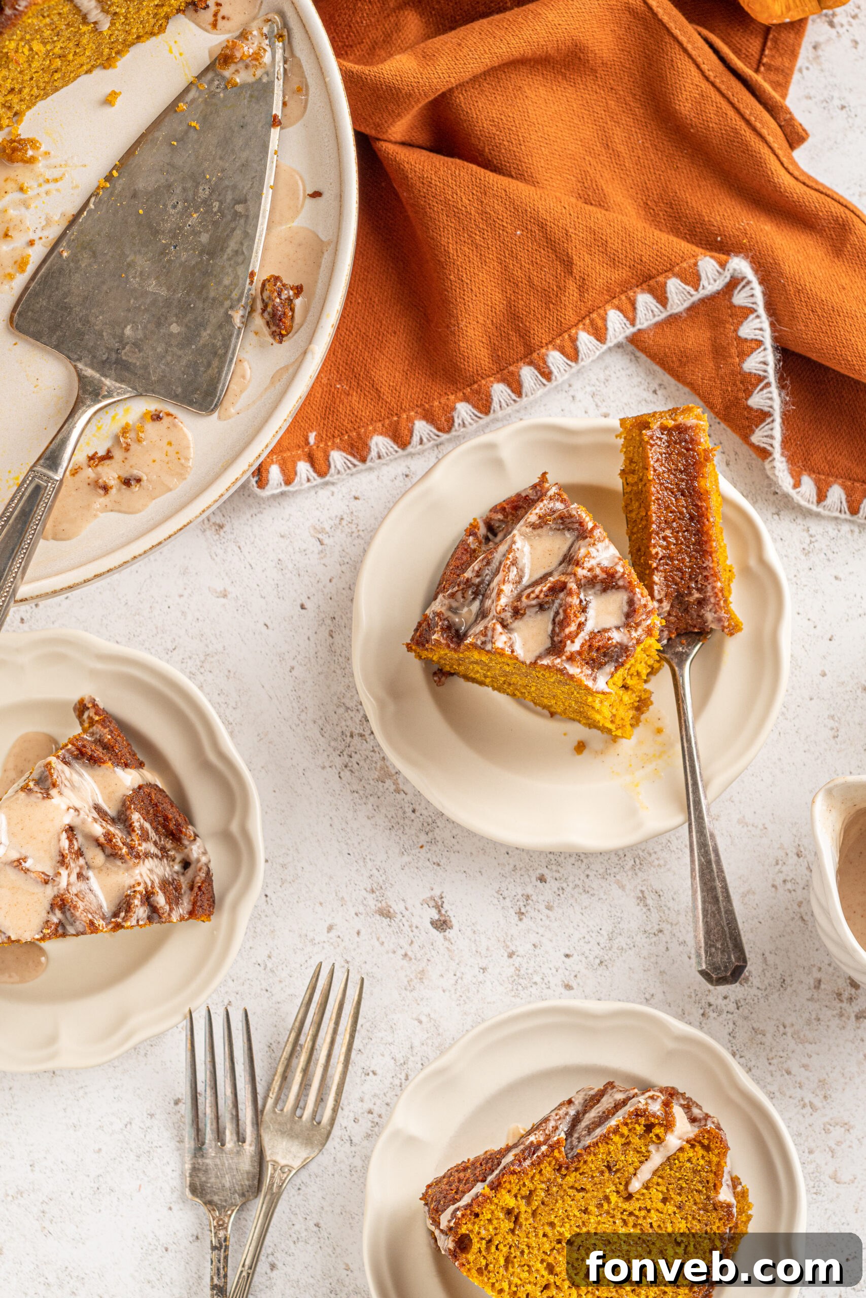 Harvest Pumpkin Bundt with Sweet Cinnamon Finish 15 Multiple slices of Pumpkin Bundt Cake with Cinnamon Sugar Glaze on white dishes, with some pieces showing bites taken out.