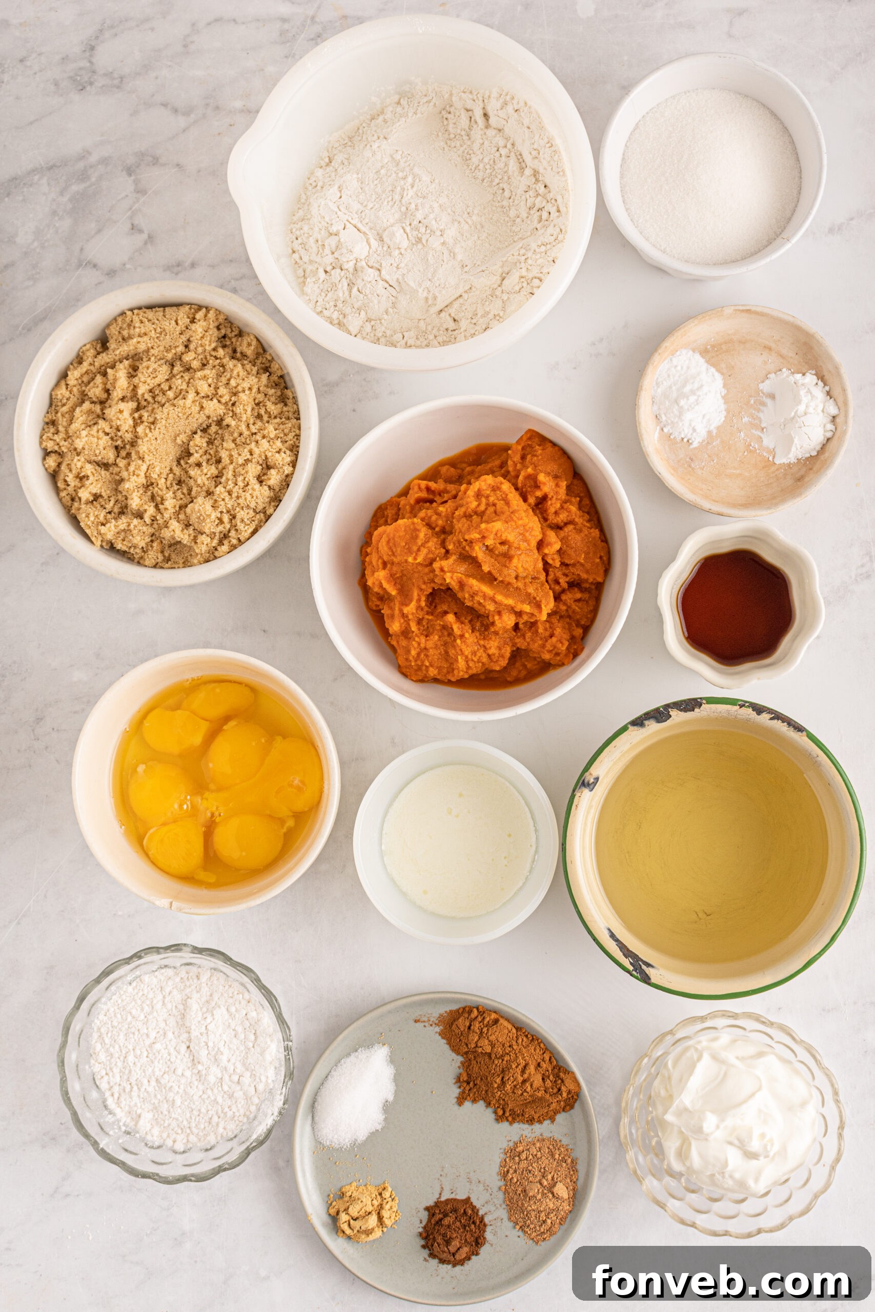 Harvest Pumpkin Bundt with Sweet Cinnamon Finish 6 Overhead view of various ingredients laid out for baking, including flours, spices, pumpkin puree, and sugars.