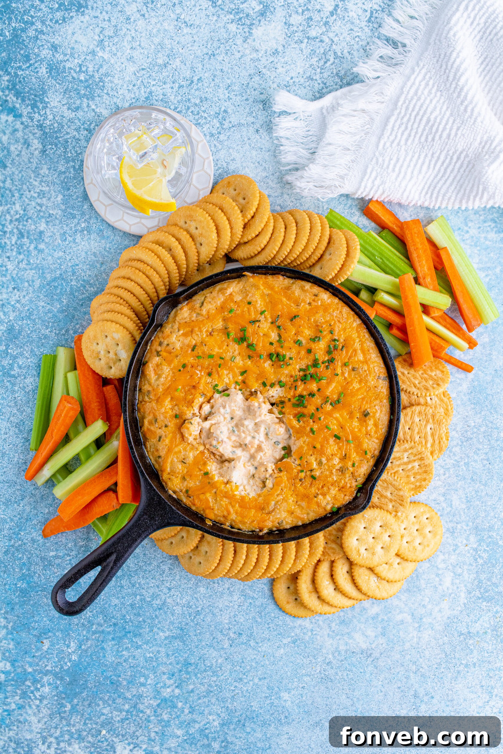 Final overhead view of the irresistible Crab Dip in a cast iron skillet, beautifully presented with a variety of dippers for sharing.