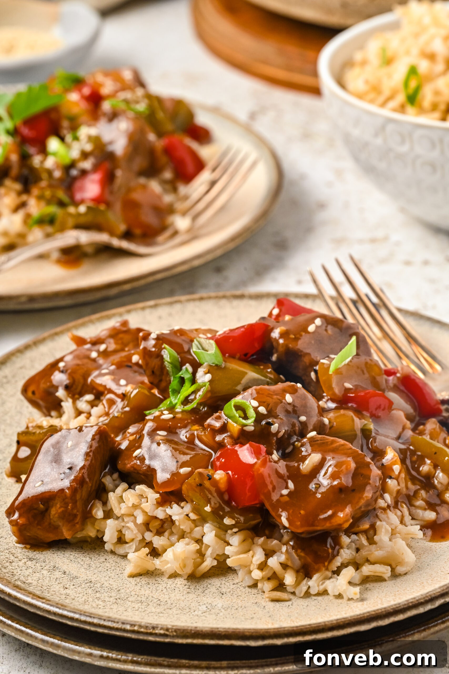 Front view of Chinese Pepper Steak on a dish served over rice.