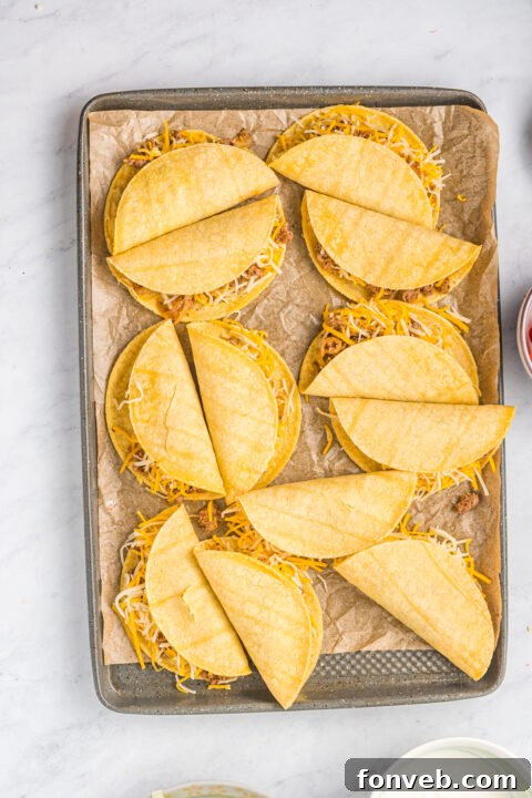 Golden Crispy Beef Tacos 15 A close-up of the baking sheet with all twelve tacos neatly arranged, ready for the oven, showing the crisping process.