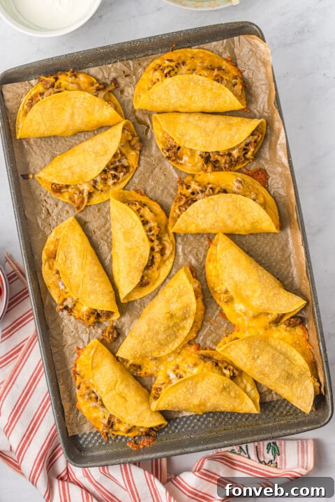 Golden Crispy Beef Tacos 16 A delicious Crispy Beef Taco, freshly baked and topped with shredded lettuce and diced tomatoes, ready to be enjoyed.