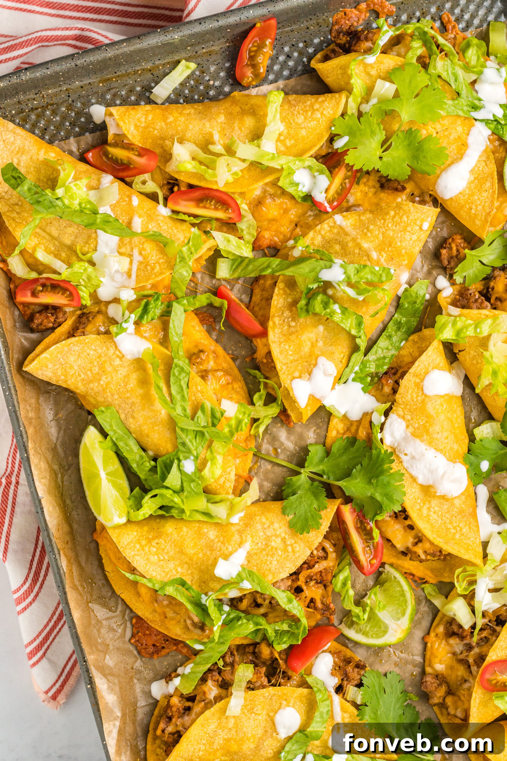 Golden Crispy Beef Tacos 3 Overhead view of freshly baked Crispy Beef Tacos on a sheet pan, ready to be served with various toppings.