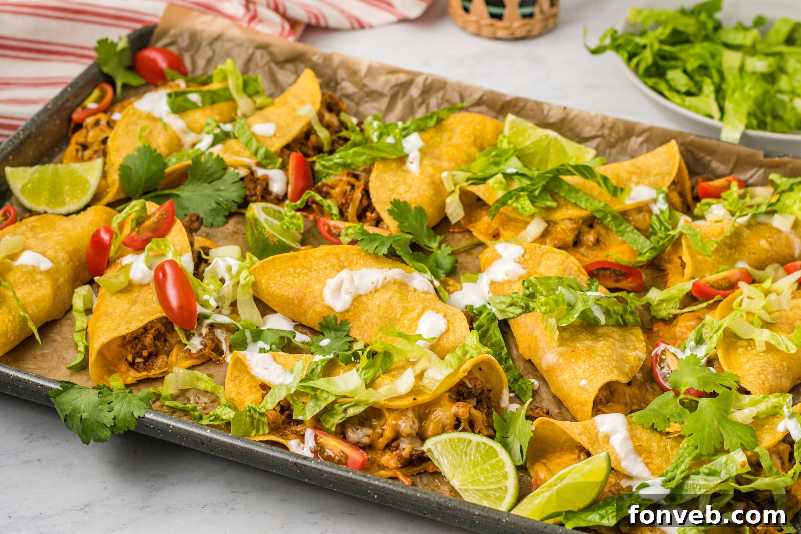 Golden Crispy Beef Tacos 8 Front view of several Crispy Beef Tacos on a sheet pan, showcasing their perfectly golden, crispy shells before serving.