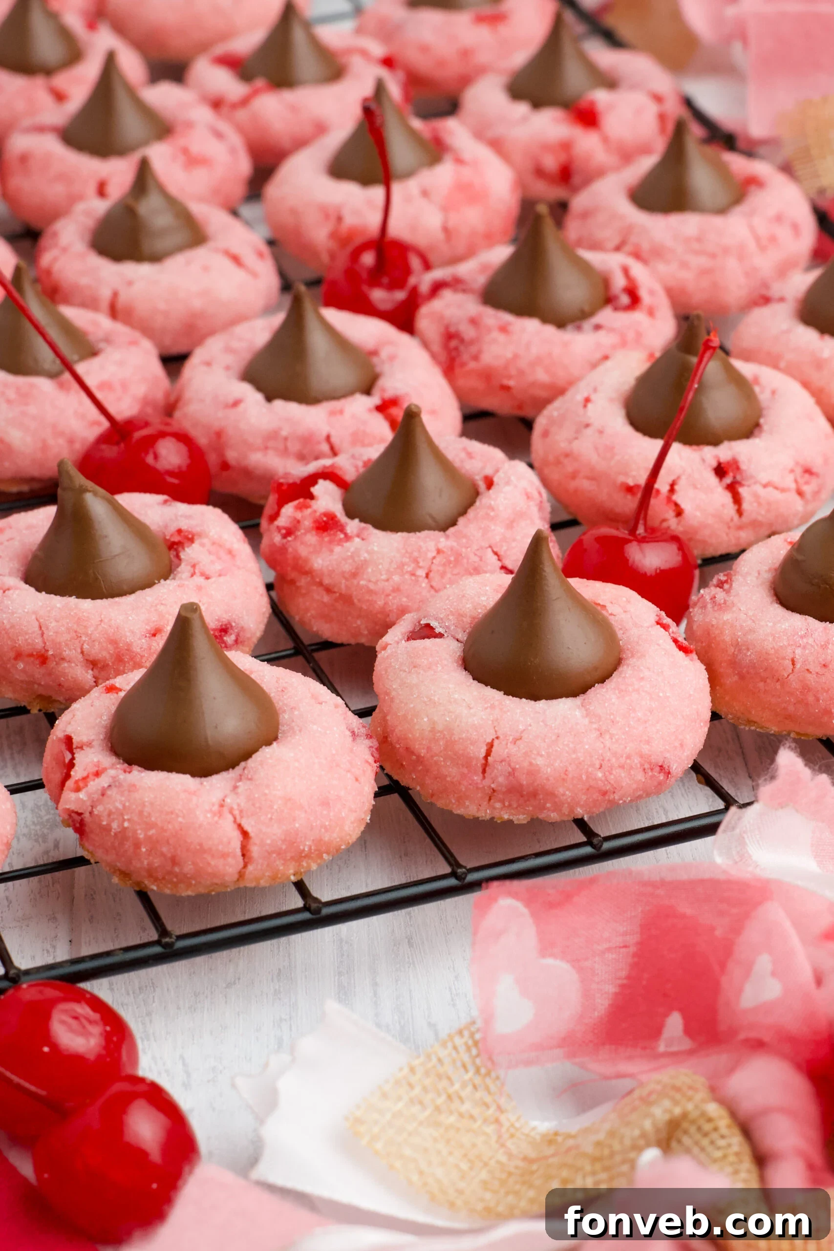 Several Cherry Blossom Cookies cooling on a black wire rack, ready to be enjoyed.