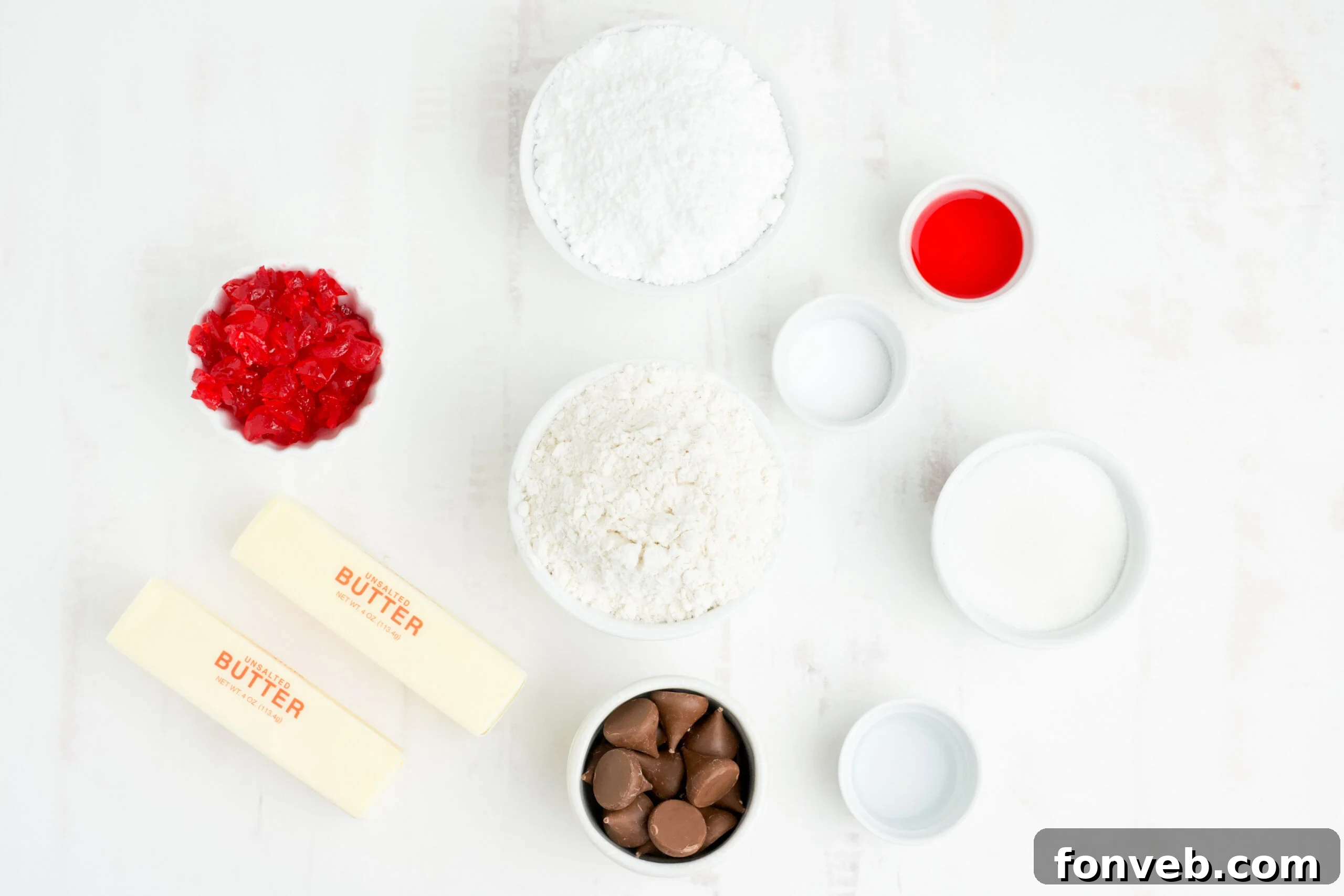 A selection of ingredients for Cherry Blossom Cookies laid out, including butter, flour, sugar, cherries, and Hershey Kisses.