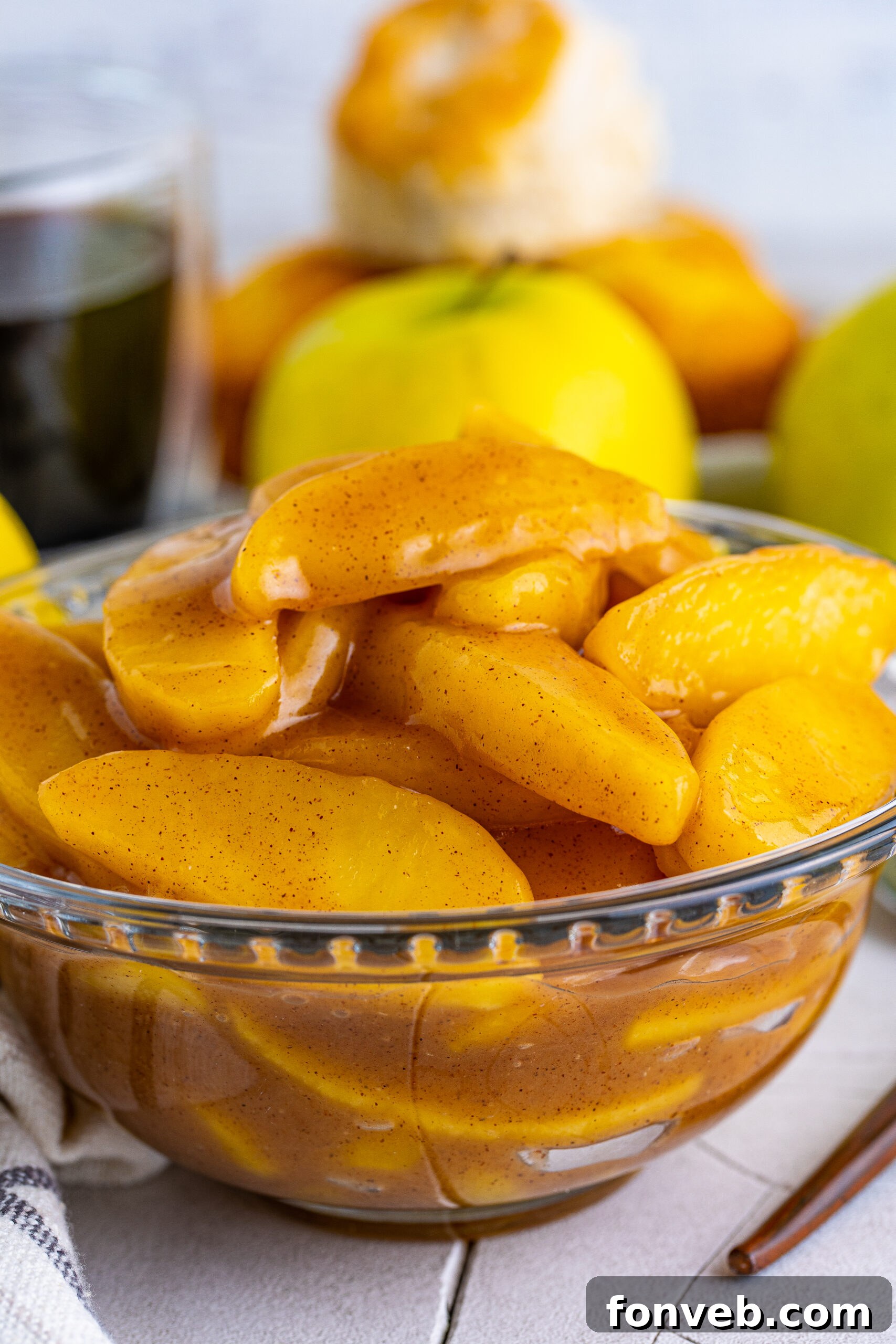 Close up view of Cracker Barrel Fried Apples in a clear glass bowl, showcasing their golden-brown color and soft texture.
