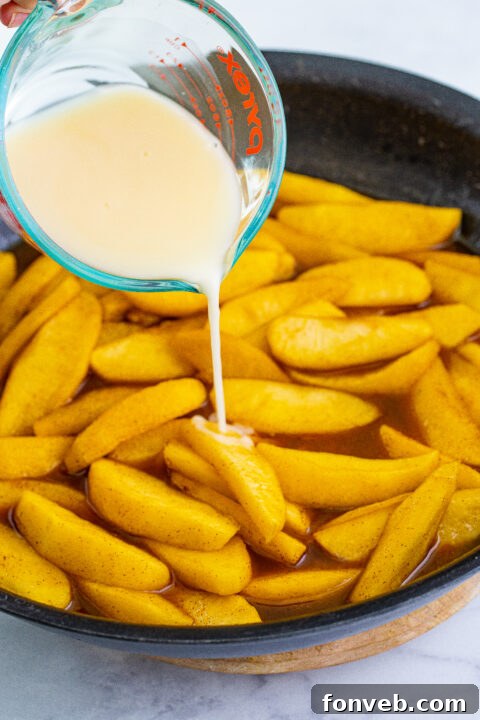 Apple juice and cornstarch being whisked together in a bowl to form a slurry.