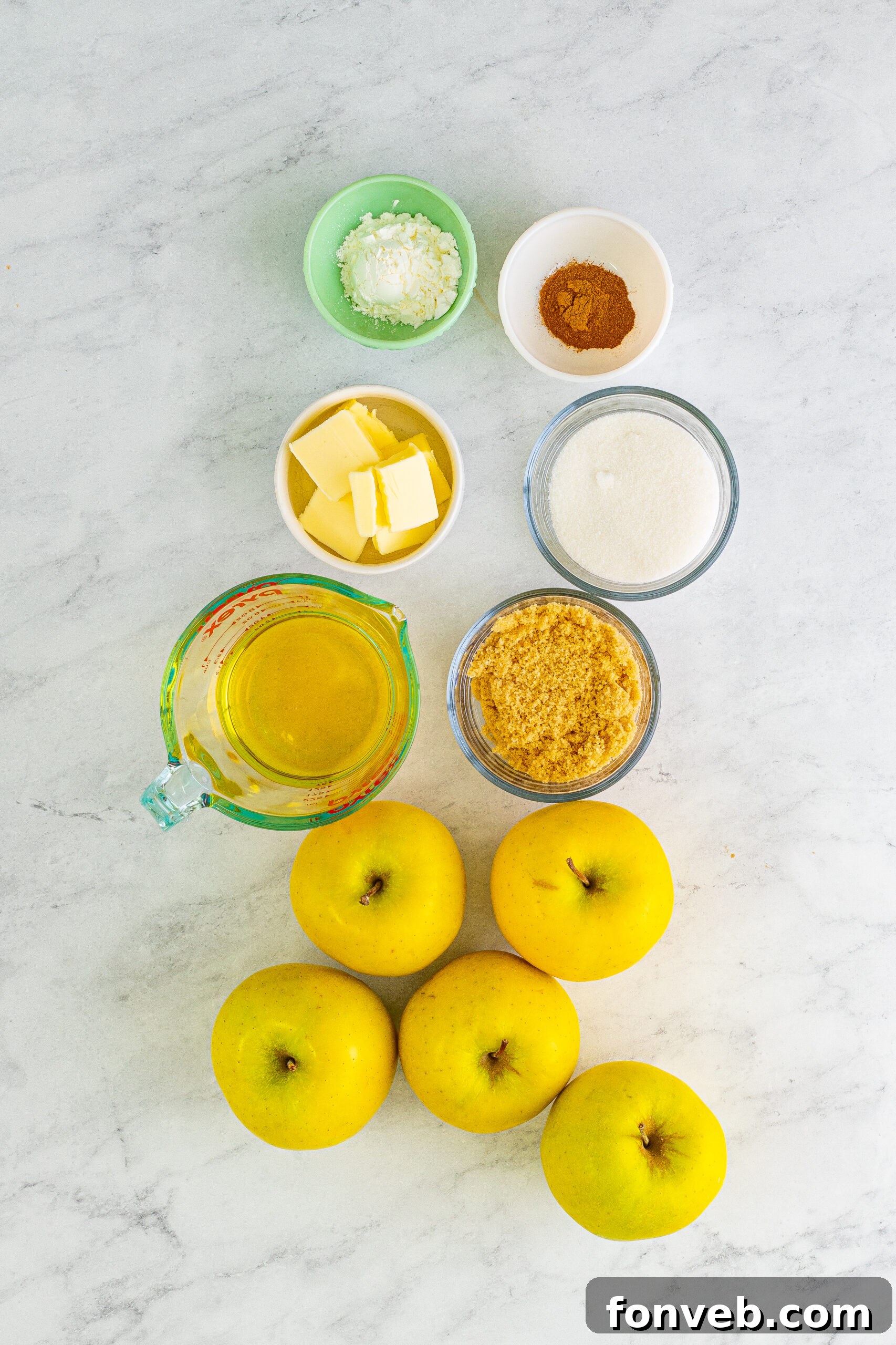 Overhead view of all the fresh ingredients needed to prepare Cracker Barrel Fried Apples, neatly arranged on a counter.