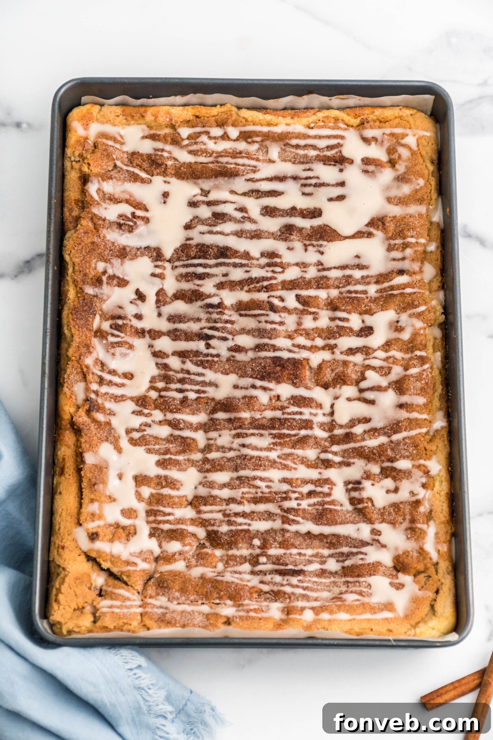 Overhead view of Snickerdoodle Cheesecake Bars in a baking pan, ready to be cut into individual servings.