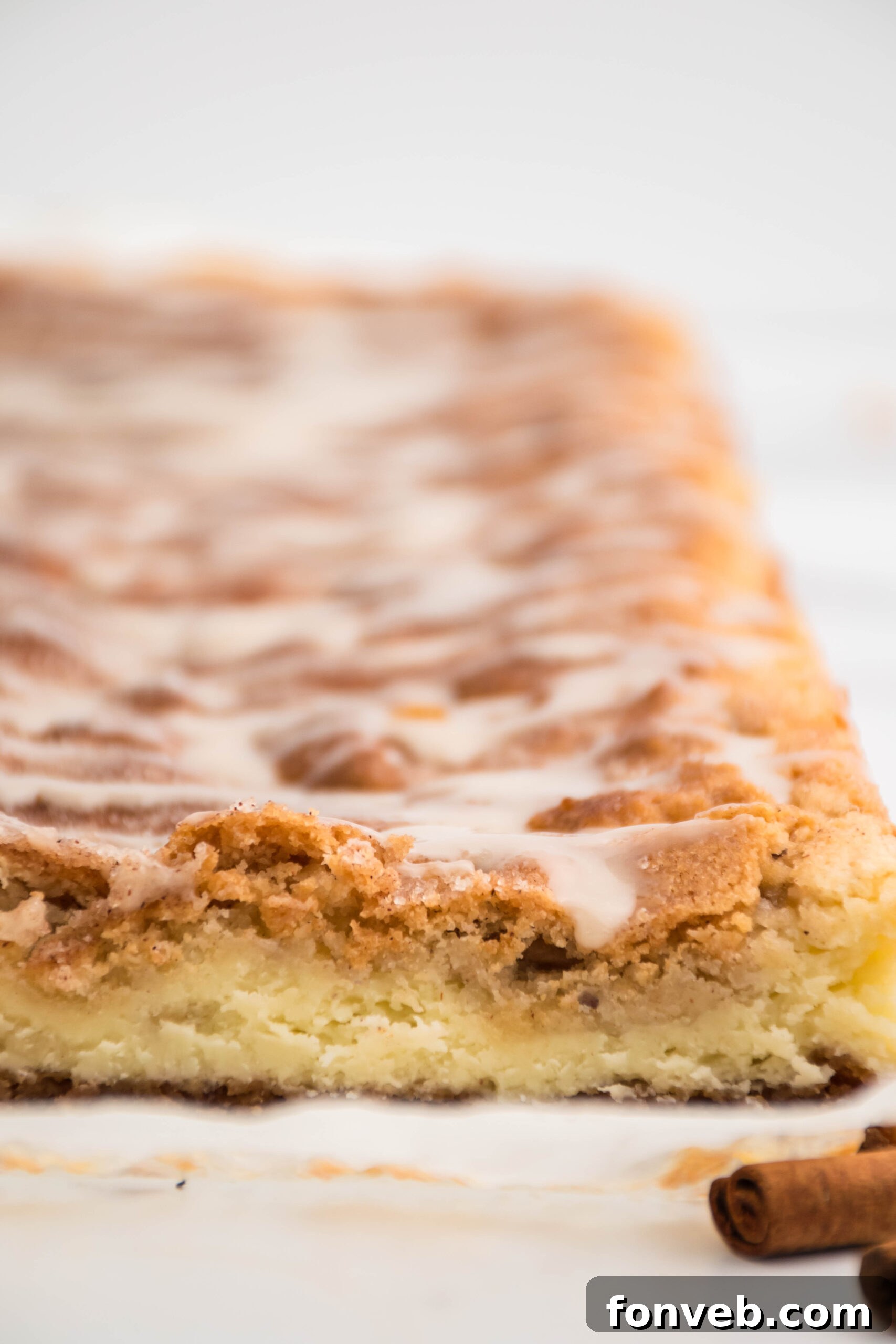 Close up front view of multiple Snickerdoodle Cheesecake Bars in a pan, sprinkled with cinnamon sugar.