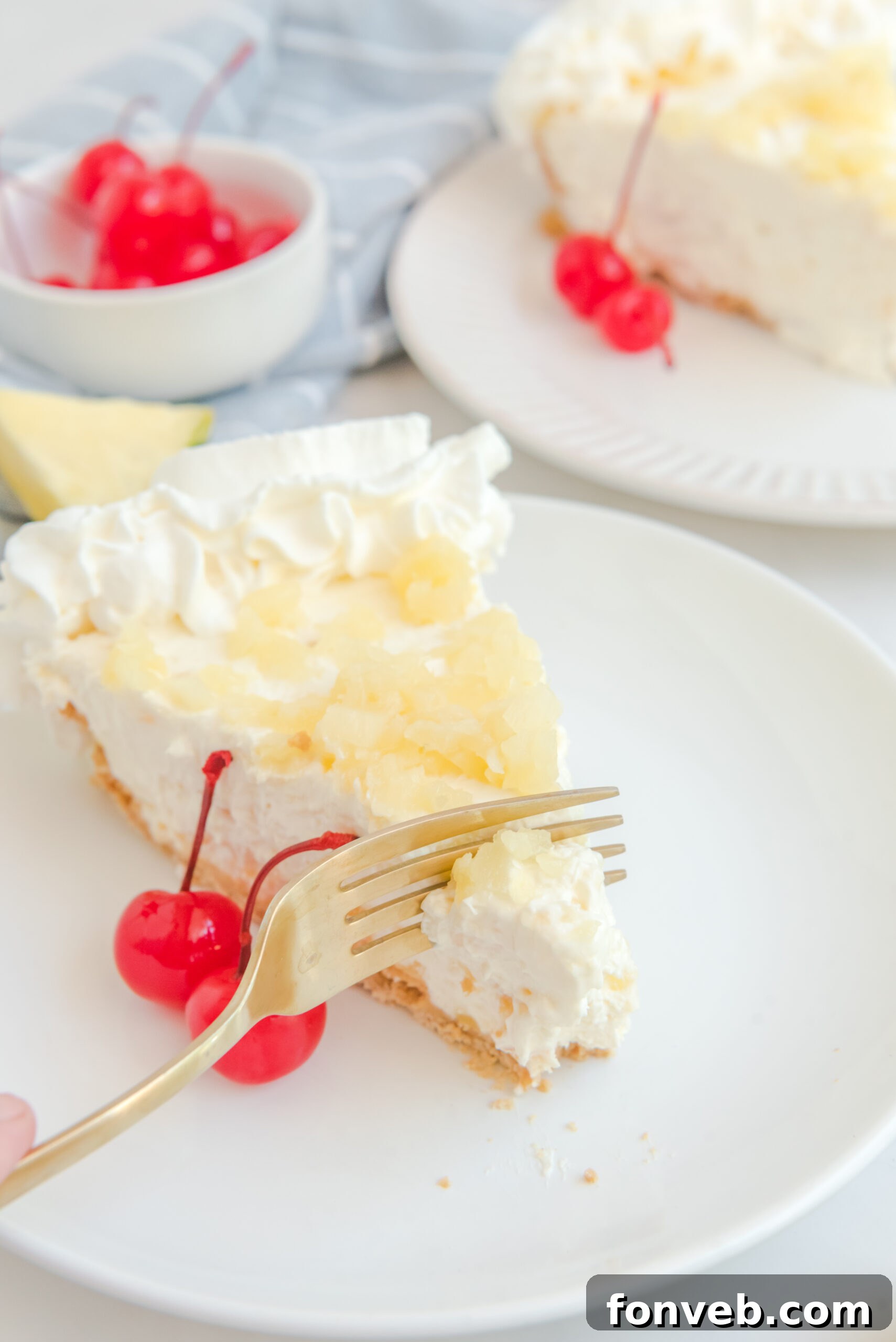 Up close view of a gold fork removing a bite of No Bake Pineapple Cheesecake.