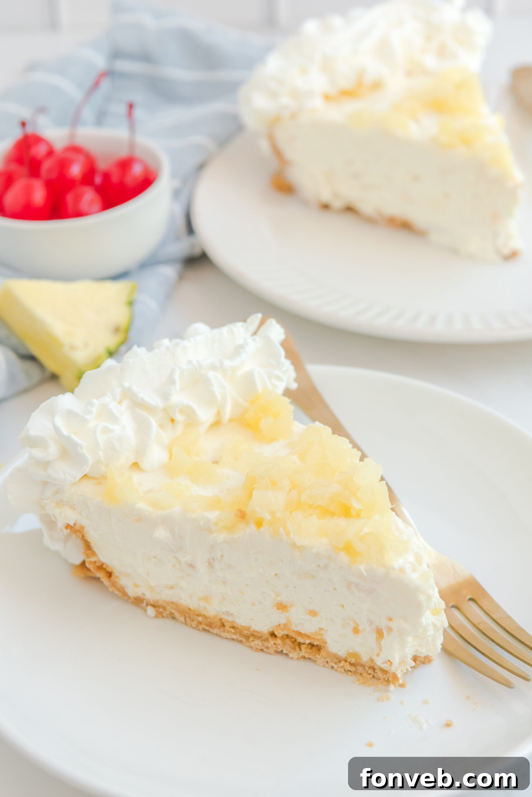 a slice of No Bake Pineapple Cheesecake Pie on a white plate topped with pineapple