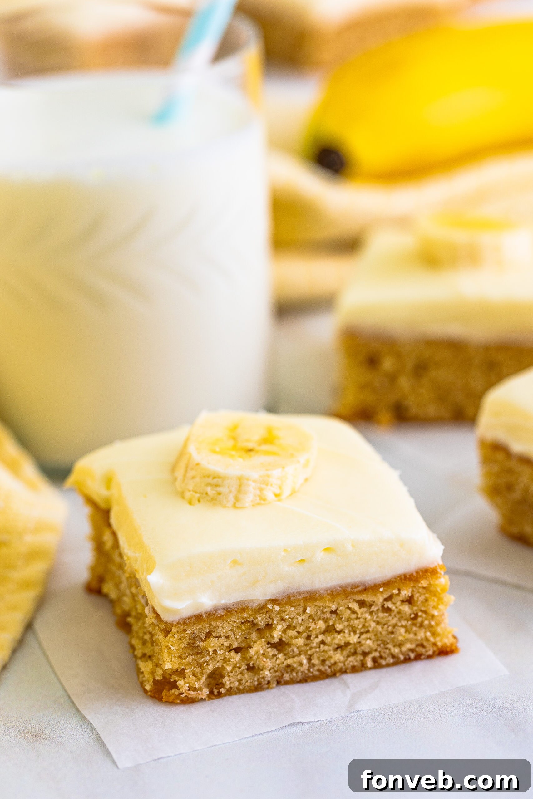 Close up view of fudgy Banana Brownies on parchment paper, highlighting their moist texture and golden-brown edges.