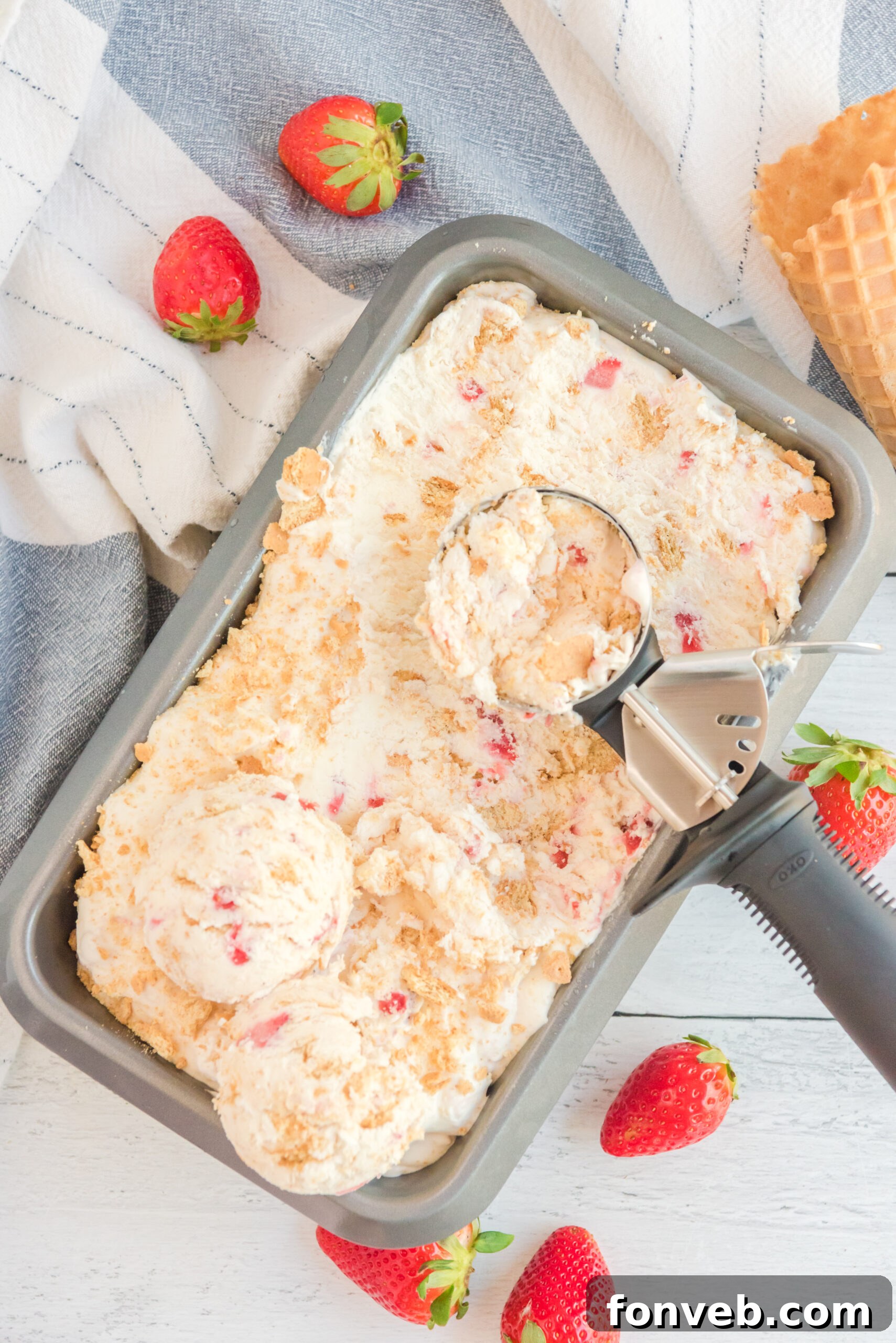 Frozen Strawberry Cheesecake Dream 2 overhead shot view of an ice cream scoop scooping Strawberry Cheesecake Ice Cream.