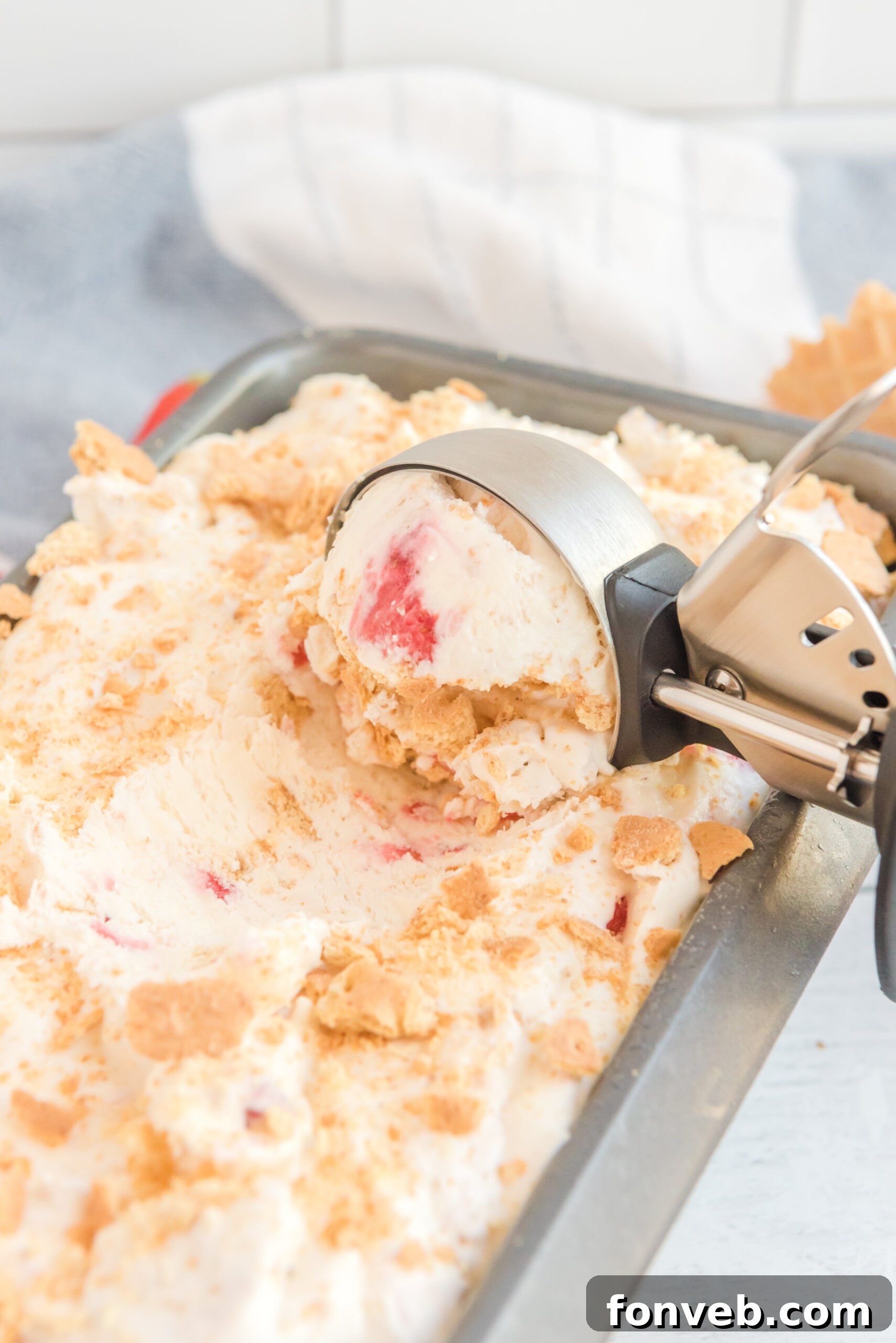 Frozen Strawberry Cheesecake Dream 3 Close up view of an ice cream scoop scooping Strawberry Cheesecake Ice Cream.